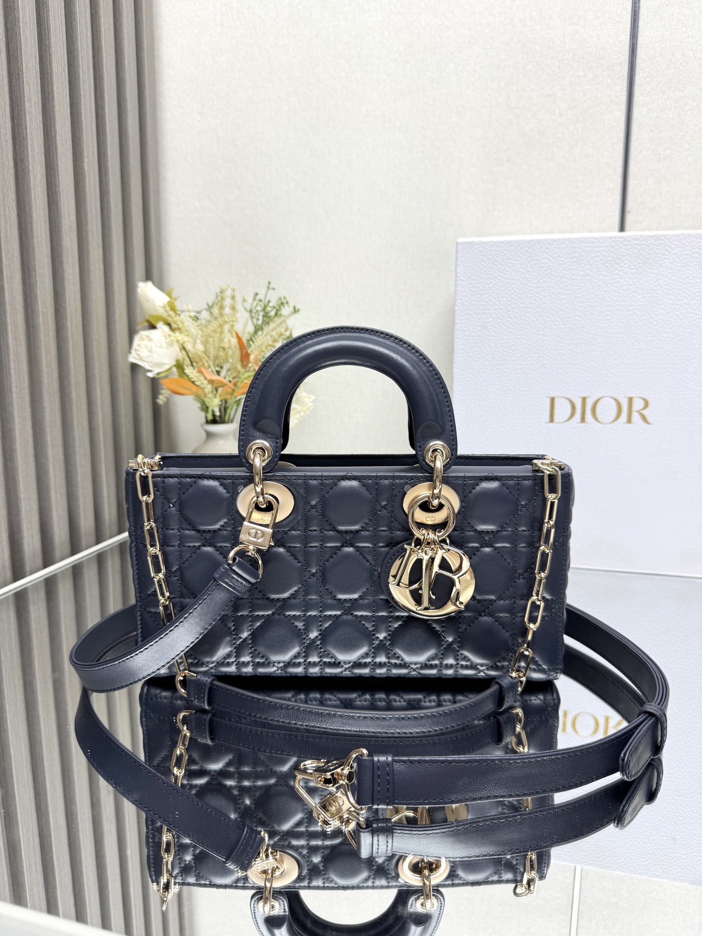 NO:855214,MEDIUM LADY D-JOY BAG 'Dark Blue Lambskin' This Lady D-Joy handbag highlights the simple aesthetics of the Lady Dior collection, embodying Dior's deep insight into elegance and beauty. Carefully crafted from black matte cow leather, with classic cannage topstitching to create eye-catching quilting details, the sophisticated sewing craftsmanship is revealed. Tonal metal D.I.O.R.  The pendant highlights elegance. The small style is equipped with a detachable chain shoulder strap and an adjustable and removable leather shoulder strap. It can be carried by hand, shoulder or cross-body. It is an ideal choice for daily styling. Detachable chain shoulder strap Removable and adjustable leather shoulder strap Model Size 26×13.5×5 cm Can store an iPhone and other accessories 238600,Dior,dior,dior,cowhide,sheepskin19860909中号 LADY D-JOY 手袋「深蓝色小羊皮」 这款 Lady D-Joy 手袋凸显 Lady Dior 系列的简约美学,集中体现了 Dior 对典雅和美丽的深刻洞见.采用黑色哑光牛皮革精心制作,以经典的藤格纹缉面线打造醒目的绗缝细节,精良的缝制工艺显露无遗.同色调金属 D.I.O.R. 吊饰彰显优雅气质.小号款式,搭配可拆卸的链条肩带和可调节、可拆卸的皮革肩带,可手提、肩背或斜挎,是日常造型的理想之选. 可拆卸链条肩带 可拆卸、可调节的皮革肩带 型号 尺寸26×13.5×5 cm 可收纳一部 iPhone和其他配饰 238600,迪奥,dior,dior,cowhide,sheepskin,Bag