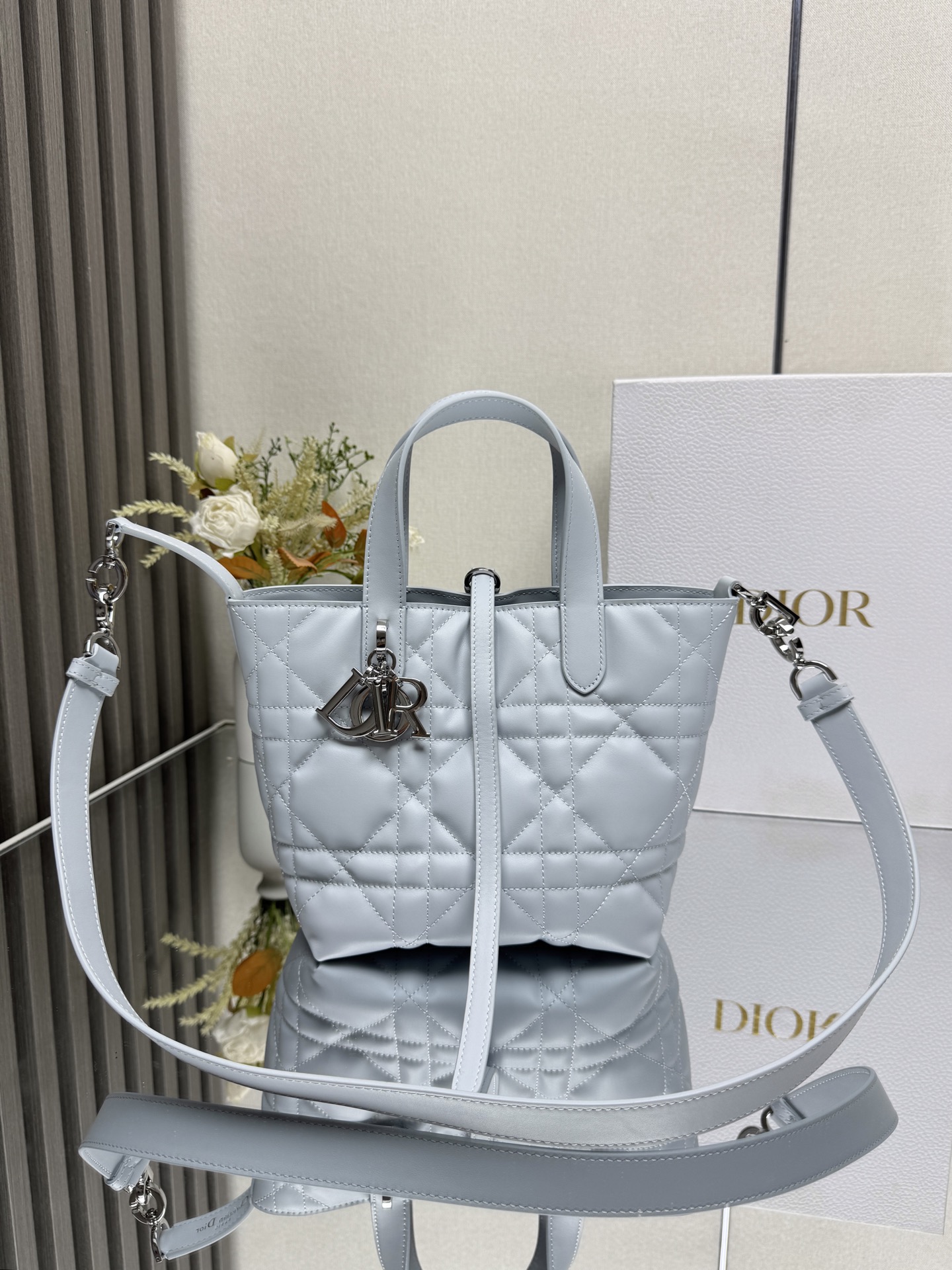 NO:855158,This Dior Toujours vertical handbag is a new product in the 2025 early spring ready-to-wear series. It is fashionable, practical and unique. It is carefully made of glacier blue cow leather and decorated with oversized cannage pattern topstitching. The spacious internal compartment can store a variety of daily necessities. It has a slim leather lace closure to safely store various items, and there is a CD Lock  Letter D knob-type buckle, adjustable on both sides, enhances style. Small style, top leather handle with detachable leather shoulder strap, can be carried by hand, shoulder or cross-body. Main body: cow leather. Lining: cow leather. Size 16×18×12cm. Style number 000670, Dior, dior, dior, cowhide.19860909这款 Dior Toujours竖版手袋是二零二五早春成衣系列新品,时尚实用,别具一格.采用冰川蓝色牛皮革精心制作,饰以超大藤格纹缉面线,宽敞的内部隔层可收纳各种日常用品.设有纤细皮革系带开合,可安全收纳各种物品,另有CD Lock 字母D旋钮式扣环,可调节两侧,提升格调.小号款式,顶部皮革手柄搭配可拆卸的皮革肩带,可手提、肩背或斜挎 主体:牛皮革里料:牛皮革 尺寸16×18×12cm 款号 000670,迪奥,dior,dior,cowhide,Bag