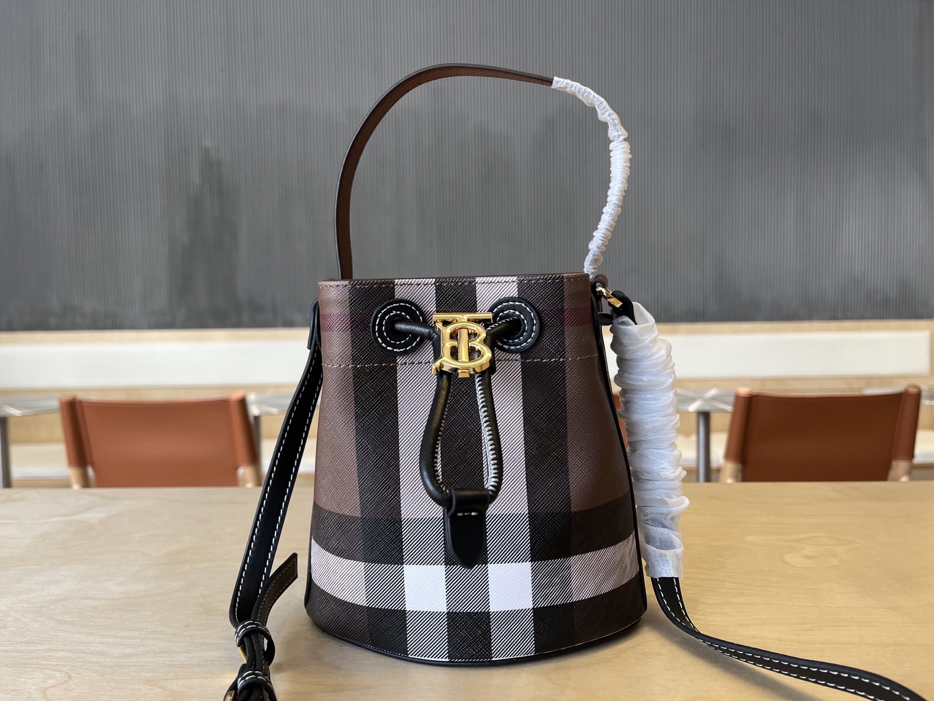 B家小迷你抽绳水桶包,装饰 Burberry 格纹,搭配意大利鞣制皮革边饰和 TB 专属标识。11、16