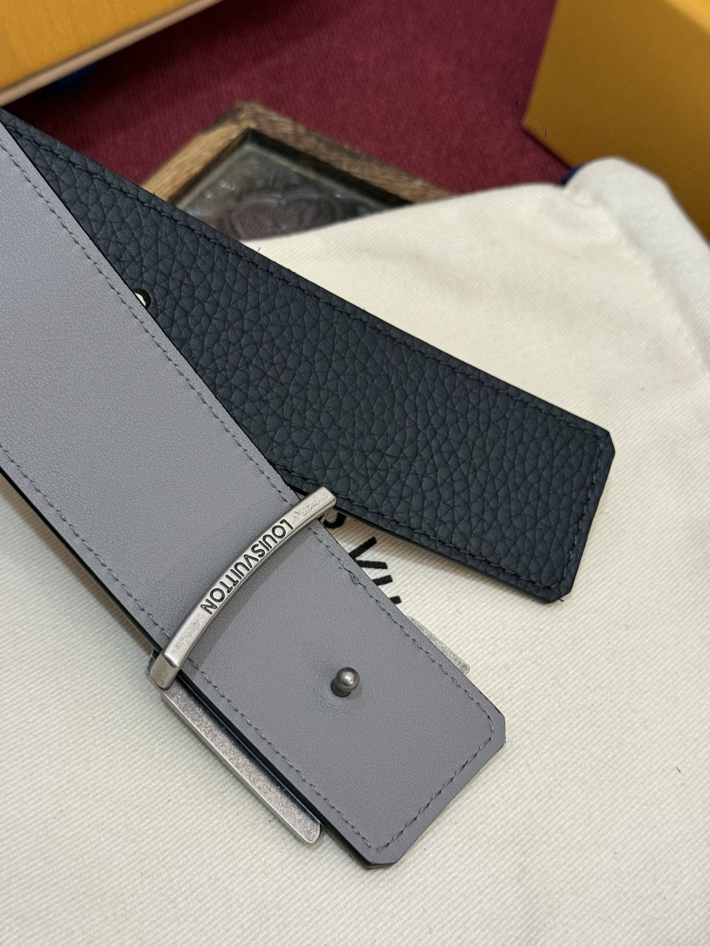 本款 Damier LV 40 毫米双面腰带做工精良，风格经典。深色牛皮革皮带与 LV 字母搭扣优雅相称