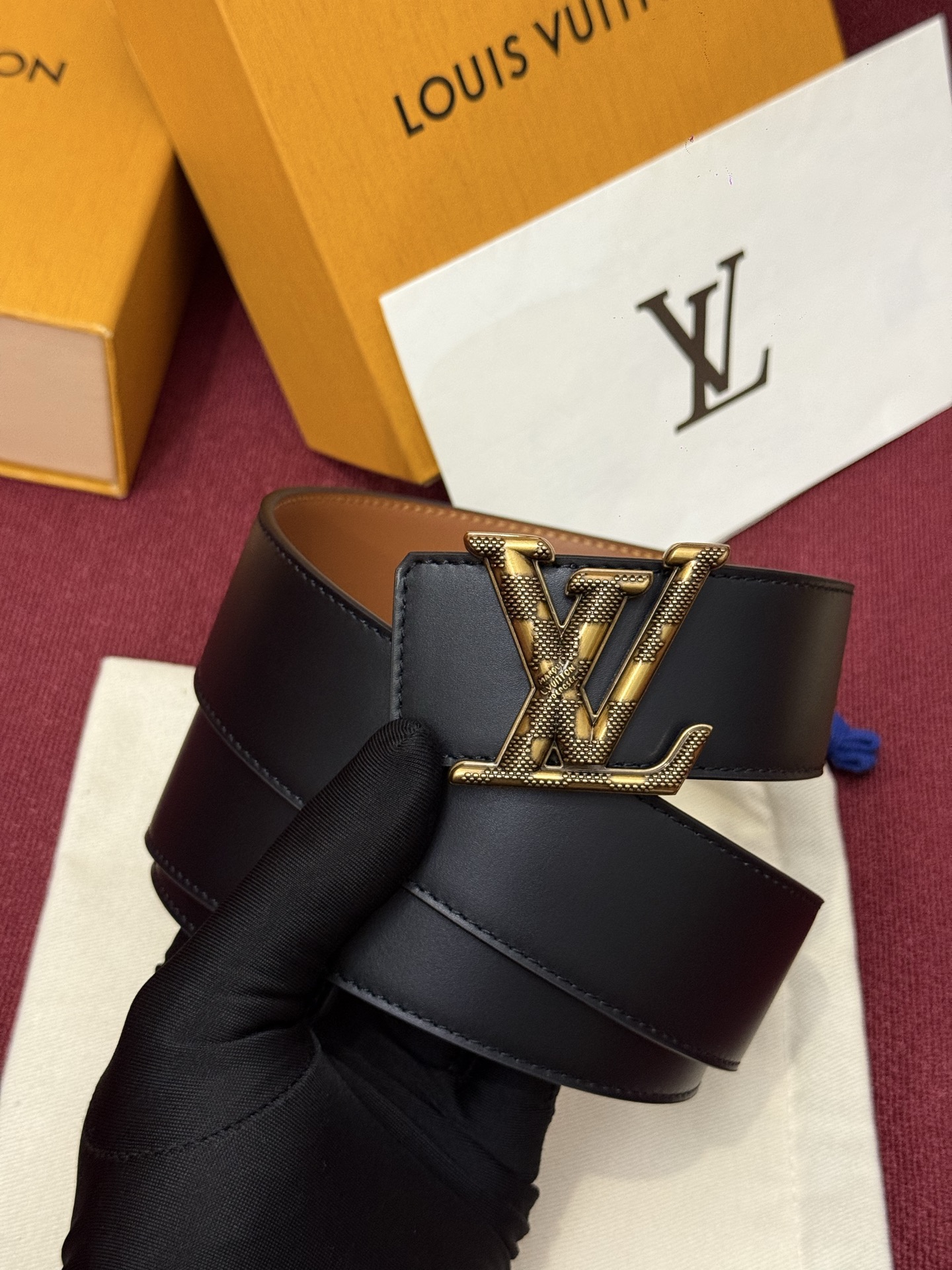 本款 Damier LV 40 毫米双面腰带做工精良，风格经典。深色牛皮革皮带与 LV 字母搭扣优雅相称