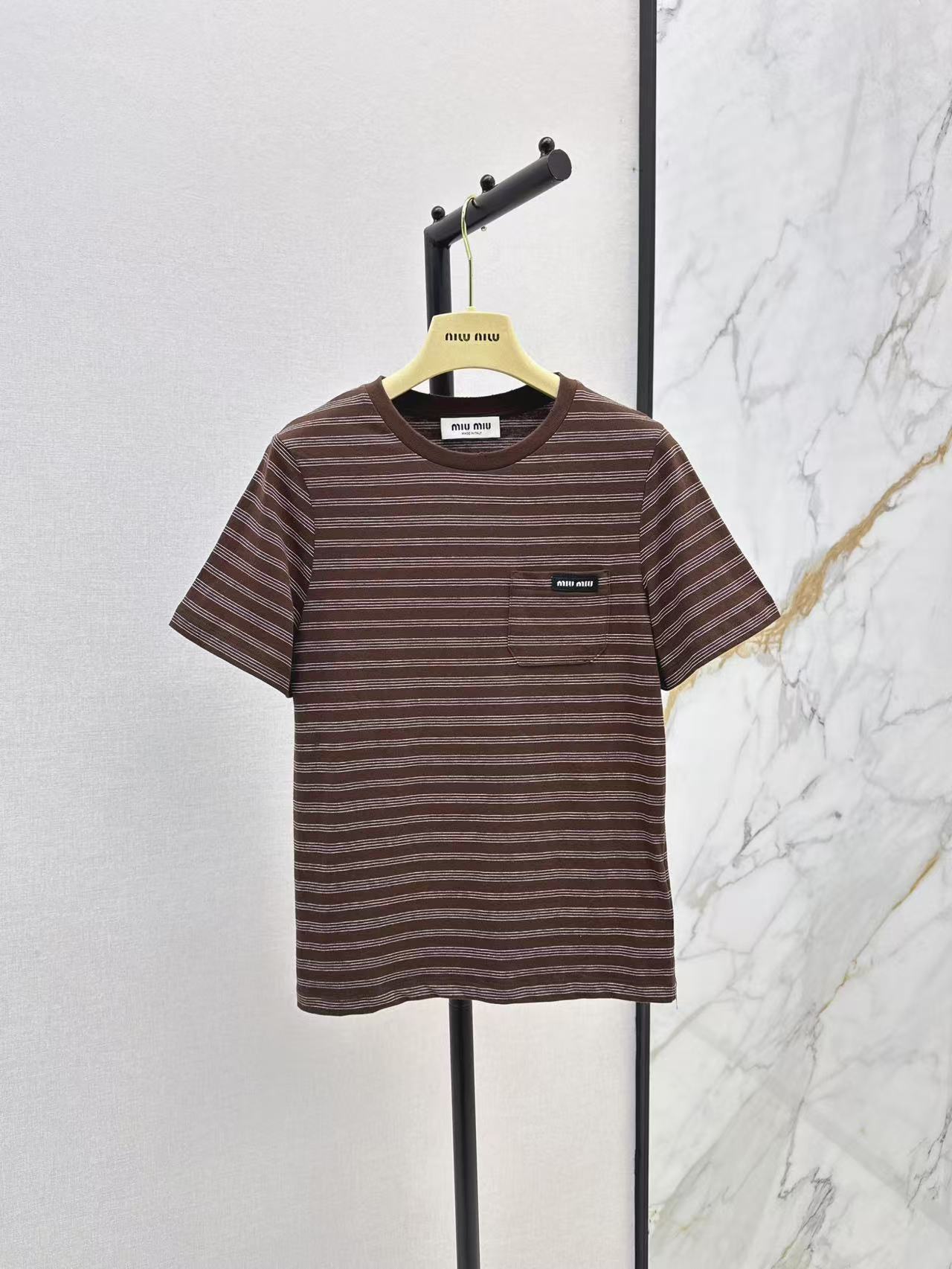 NO:297564,Miu 25Ss—————The latest Lad brown striped short-sleeved T-shirt in early spring. Retro modern atmosphere. The chest logo patch adds a sense of design to the overall casual atmosphere. The upper body is absolutely fine. It is versatile and relaxing. The style is comfortable and comfortable. It is a classic item that looks good even when wearing and layering. One-color spot-on sml, miumiu, T-shirt,tees, t-shirt,alexander wang19860909Miu 25Ss————早春最新款拉德咖色系条纹短袖T恤 复古摩登氛围感 胸前徽标贴饰在整体的休闲氛围中增添设计感 上身绝对不出错 百搭有松弛感 版型合体舒适 随性自在 单穿叠穿都好看的经典单品 一色现货发售sml,,miumiu,T-shirt,tees，t-shirt,alexander wang,Women's clothing