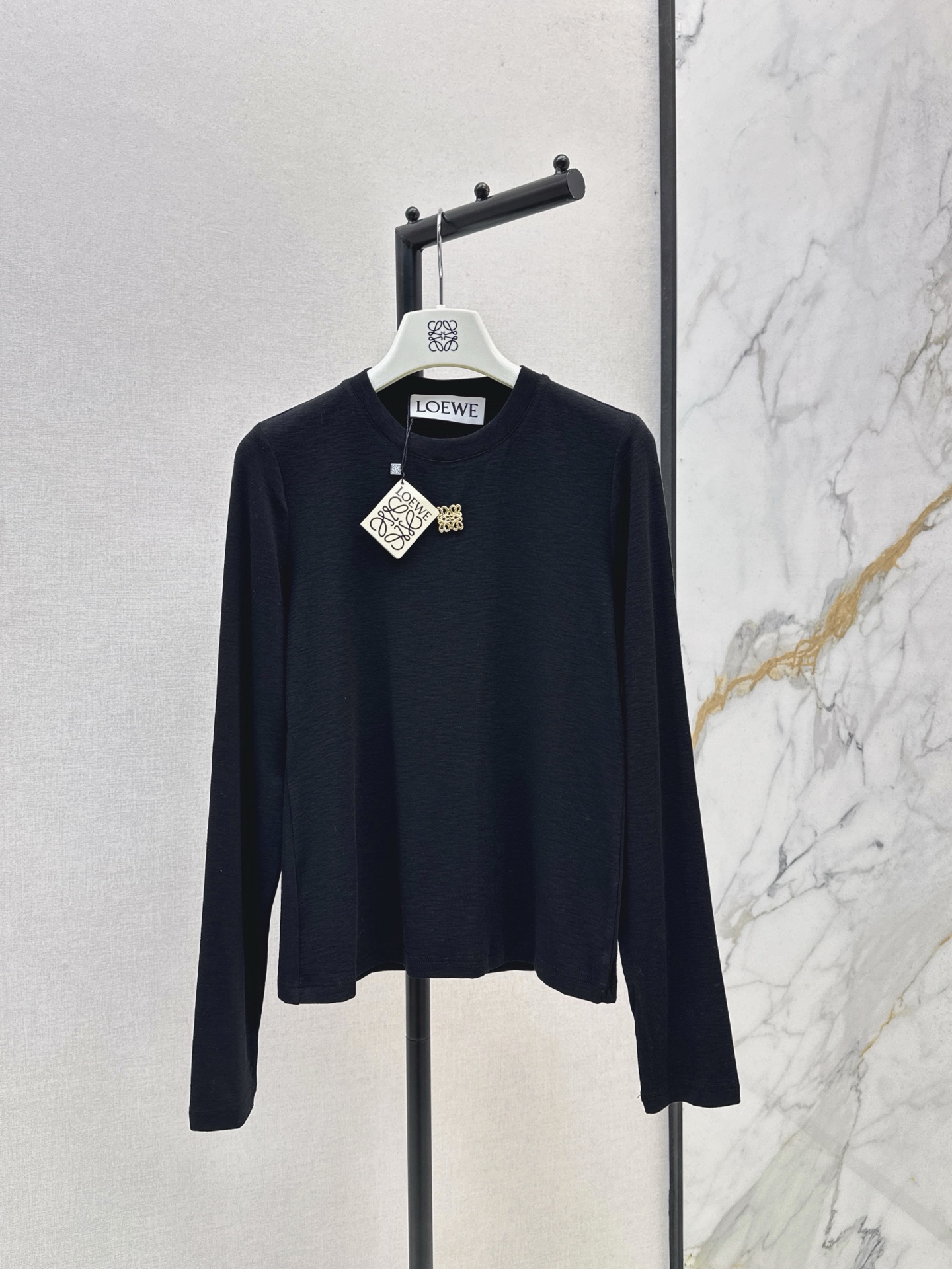 NO:535321,Loe 25Ss———The latest hardware decorative basic round neck base shirt in autumn and winter. Pure cotton fabric texture is comfortable and elastic. Slim round neck base cut. The three-dimensional metal totem logo is embellished in the center of the chest to highlight the brand style. It has a strong elastic and close feeling, visually narrow and lengthened. Slim fit and slim look. It is very fashionable and stylish when worn alone. Two colors are available for sale in stock. Loewe, alexander wang19860909Loe 25Ss———秋冬最新款五金装饰基础款圆领打底衫 纯棉面料质感舒适弹力十足 修身圆领打底裁剪 胸口居中位置点缀立体金属图腾徽标 凸显品牌格调 弹性贴身感十足,视觉收窄拉长 修身显瘦 单穿内搭都出彩时髦 两色现货发售sml,,loewe,alexander wang,Women's clothing