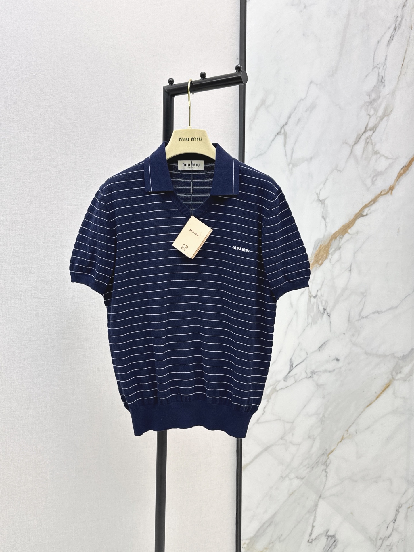 NO:862892,Miu 26Ss - the latest navy blue striped Polo short-sleeved sweater for spring and summer. Custom-spun crisp pure cotton yarn. Custom-dyed navy blue to slim down skin tone. Gentle and age-reducing Polo shirt style. Small V-neck design, cleverly lengthens the neck line. Classic logo letter jacquard on the chest highlights the style. Fine stitching details inside and outside. Loose fit with ribbed waist, comfortable and slim. Versatile for daily wear.  One color ready for sale sml,,miumiu,T-shirt,19860909Miu 26Ss———春夏最新款夏日藏蓝色条纹Polo短袖针织衫 对版定纺的清爽纯棉纱线 定染气质藏青色显瘦衬肤色 减龄温柔Polo衫版型 小V领设计超心机巧妙拉长颈部线条 胸口经典logo字母标识提花凸显格调 里里外外精细缝盘细节 松身版型搭配罗纹收腰舒服又显瘦 日常实穿百搭拉比例 一色现货发售sml,,miumiu,T-shirt,,Women's clothing