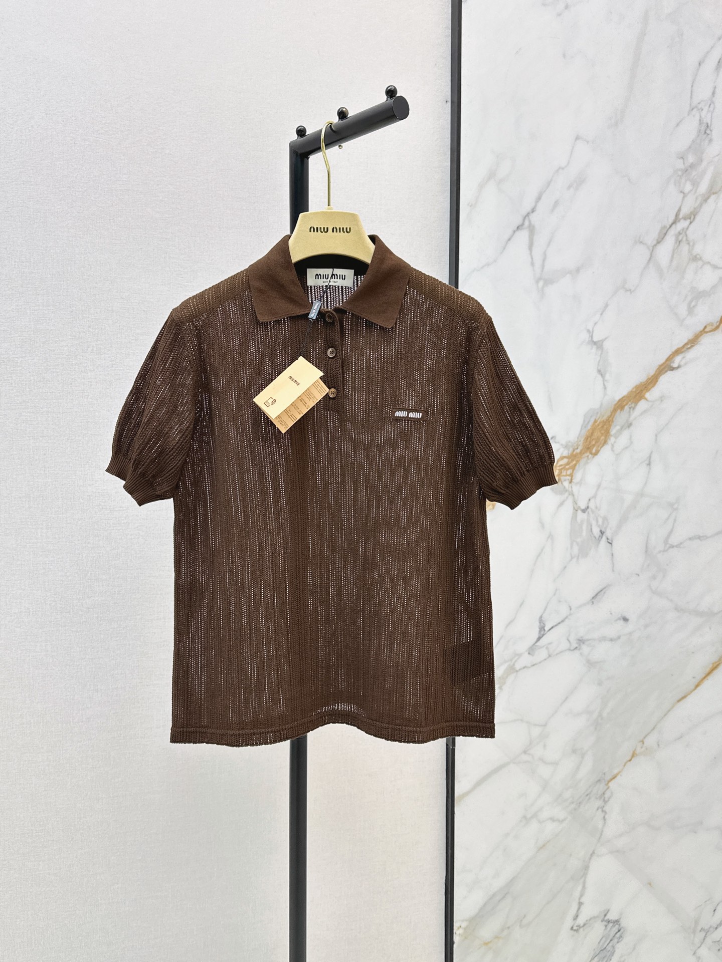 NO:878359,Miu 26Ss————The latest hollow lapel knitted brown Polo shirt for spring and summer. It is very suitable for spring and summer. Classic Polo collar + mother-of-pearl buttons. Full of retro college style. The slightly wide version of the shoulder is super friendly to the body. It is embellished with the classic brand letter logo pattern. It can easily show miu’s unique age-reducing look when worn alone or layered. The smart brown color is suitable for all kinds of styles. It is white and high-end~ One color ready for sale sml,, miumiu,19860909Miu 26Ss————春夏最新款镂空翻领针织咖色Polo衫 春夏穿超合适 经典Polo领+贝母纽扣 复古学院风满满 正肩微阔版型对身材包容度超友好 经典品牌字母logo图案点缀 单穿叠搭都能轻松呈现miu独有的减龄造型 巧棕色适配各类造型 显白又高级～ 一色现货发售sml,,miumiu,,Women's clothing