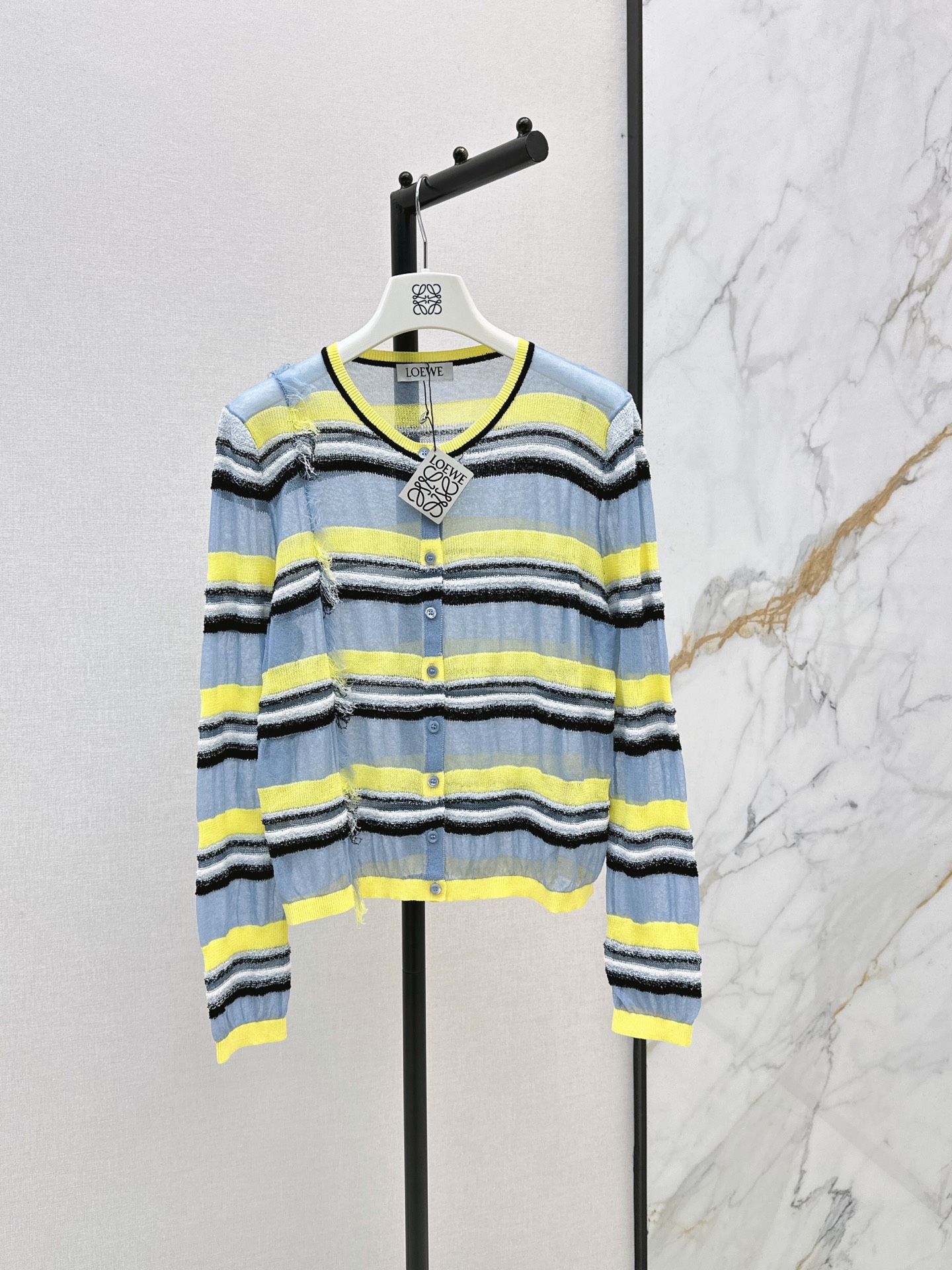 NO:885990,Loe 26Ss————The latest spring and summer vacation series yellow and blue striped see-through knitted cardigan Loewe island resort style striped knitted eye-catching blue and yellow vertical stripes hit the center with a casual artistic sense and relaxed atmosphere. Customized cotton blended yarn of various specifications. Highly saturated yellow and blue embedded in off-white and yellow to restore the vertical stripe design of multiple textures. Light and breathable with a hazy atmosphere. The details are full of vacation feeling.  Two-color sml,,loewe,loewe,19860909Loe 26Ss————春夏最新款度假系列黄蓝条纹透视针织开衫罗意威海岛度假风条纹针织 醒目蓝黄竖条纹一眼击中心巴 自带随性艺术感与松弛氛围 定制多种不同规格的棉质混纺纱 高饱和黄和蓝嵌入米白和黄色还原多种肌理的竖条纹设计 轻薄透气自带朦胧氛围感 细节里全是度假感 两色sml,,loewe,loewe,,Women's clothing