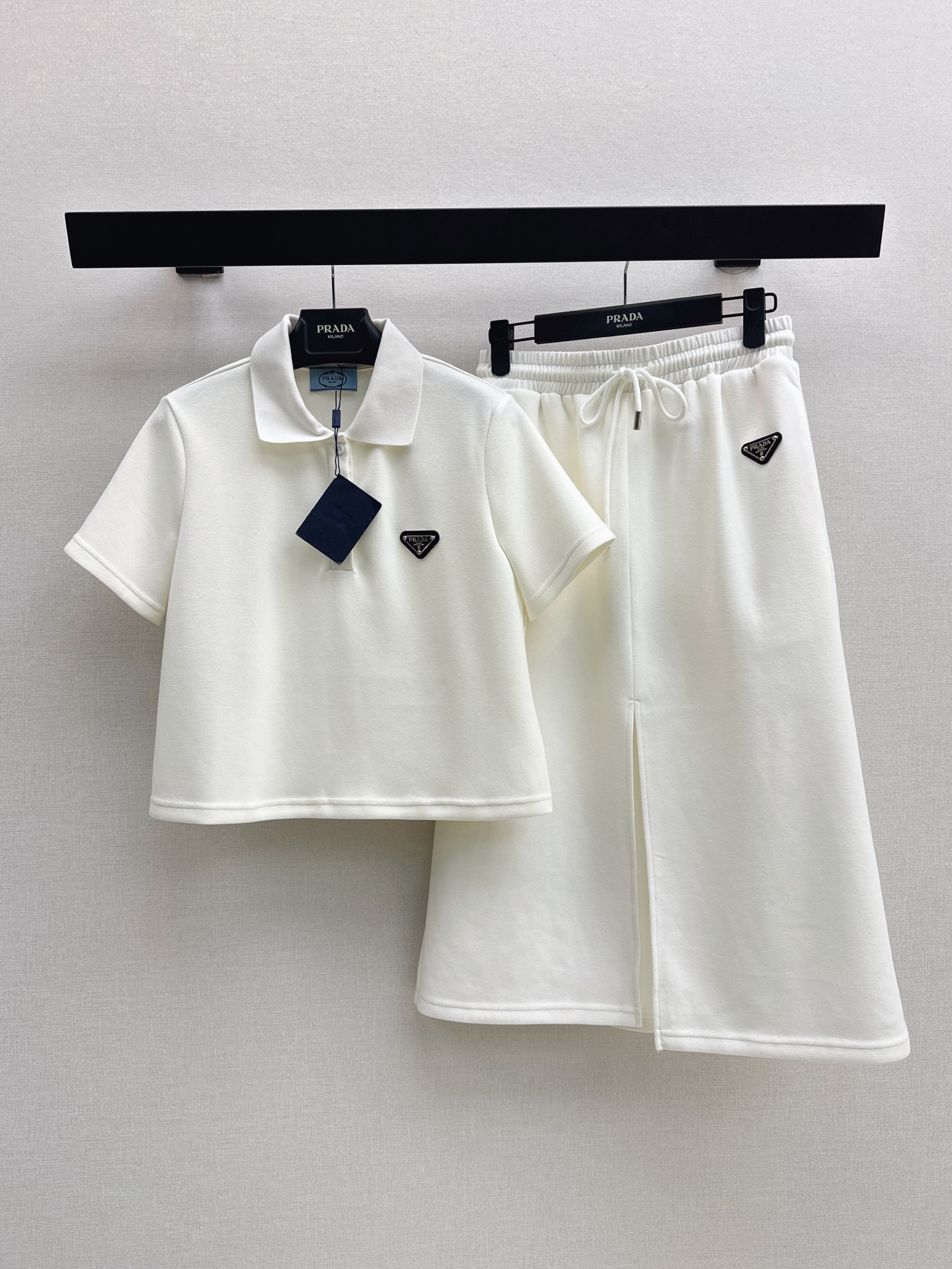NO:887394,PD 26Ss————The latest spring and summer casual suit with triangle logo decoration, short polo top + front slit skirt. The triangle logo that comes with it is low-key and textured. The fabric is soft and very stiff. It is not stuffy in the summer. It can be worn for daily appointments and commuting. White is refreshing and age-reducing. Black is cool and slim. Two colors with eyes closed. Paired with sneakers, you will be a energetic girl. One set, two colors sml, sneakers, skirts,19860909PD 26Ss————春夏最新款三角标装饰休闲套装短款polo上衣+前开叉半身裙 自带的三角标低调又有质感 面料软乎乎的还很挺括 夏天穿也不闷热 日常出门约会通勤都能穿 白色清爽减龄 黑色又酷又显瘦 两色闭眼入 搭运动鞋就是元气少女 一套出 两色sml,,sneakers,skirts,,Women's clothing