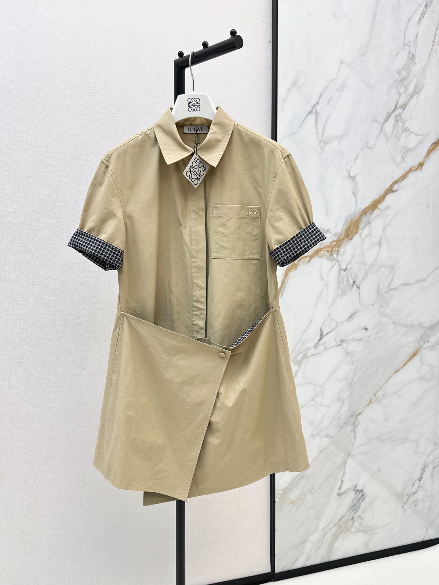 NO:899277,Loe 26Ss - the latest khaki irregular shirt dress for early autumn. Made of crisp and stylish cotton fabric. Folded plaid short sleeves. Simple pockets on the chest + logo embellishment. Irregular wrapped hem cut and fastened with buttons. The lining is plaid design. The loose version makes you look slimmer and hides body fat. It can be worn for daily commuting, shopping and dating. It is simple and has a sense of design. Effortlessly wear it to give you a sense of intellectual relaxation.  One color smlxl,,loewe,skirts,shirts,T-shirt,19860909Loe 26Ss————早秋最新款卡其色不规则衬衫裙 棉质面料挺括有型 翻折格纹短袖 胸前简约口袋+logo点缀 不规则围裹下摆裁剪纽扣固定 内里是格纹设计 宽松版型显瘦藏肉一绝 日常通勤 逛街约会都能穿,简约又有设计感 不费力穿出知性松弛感 一色smlxl,,loewe,skirts,shirts,T-shirt,,Women's clothing