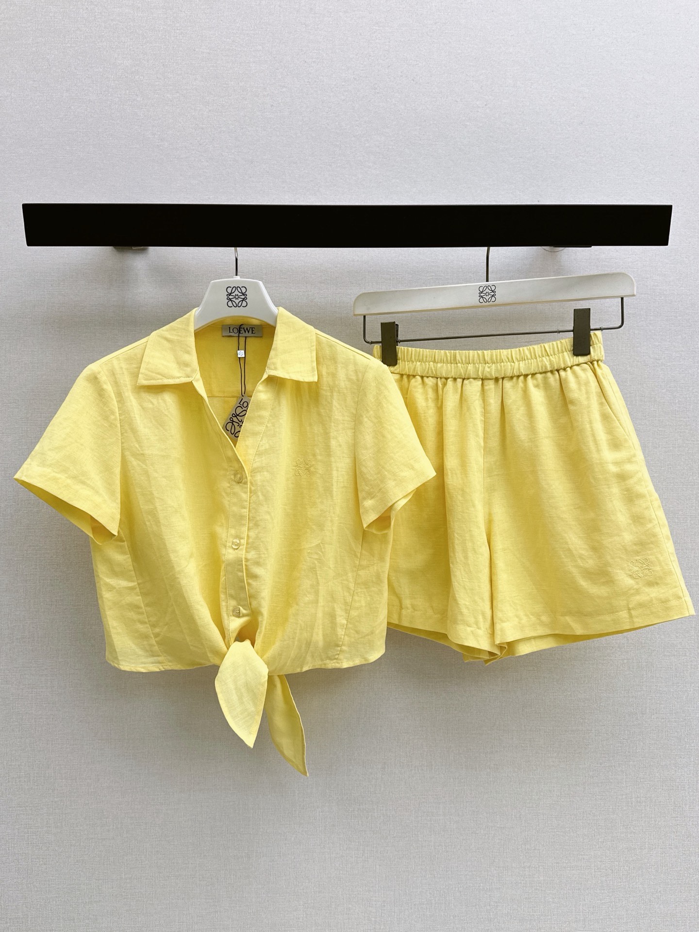 NO:927505,Loe 26Ss - the latest French style lazy casual style linen suit with lace design in spring and summer. Short lapel shirt + elastic waist wide leg shorts. The embroidered letter logo decoration is very fashionable. The rabbit ear lace design on the hem adds a sense of style. It has a casual daily street style feel. It is also very popular when worn on vacation. It is made of cotton and linen fabrics, which is comfortable and breathable. A set of daily lazy wear. It is classic, durable and easy to wear.  Three-color sml,,loewe,shorts,shirts,19860909Loe 26Ss————春夏最新款法式慵懒休闲风系带设计亚麻套装 翻领短款衬衫+松紧腰阔腿短裤 刺绣字母logo装饰很洋气 下摆兔耳朵系带设计增添造型感 自带有休闲的日常街拍Feel 度假穿它也很出片 采用棉麻面料舒适透气 一套日常懒人穿搭 经典耐看又好穿 三色sml,,loewe,shorts,shirts,,Women's clothing