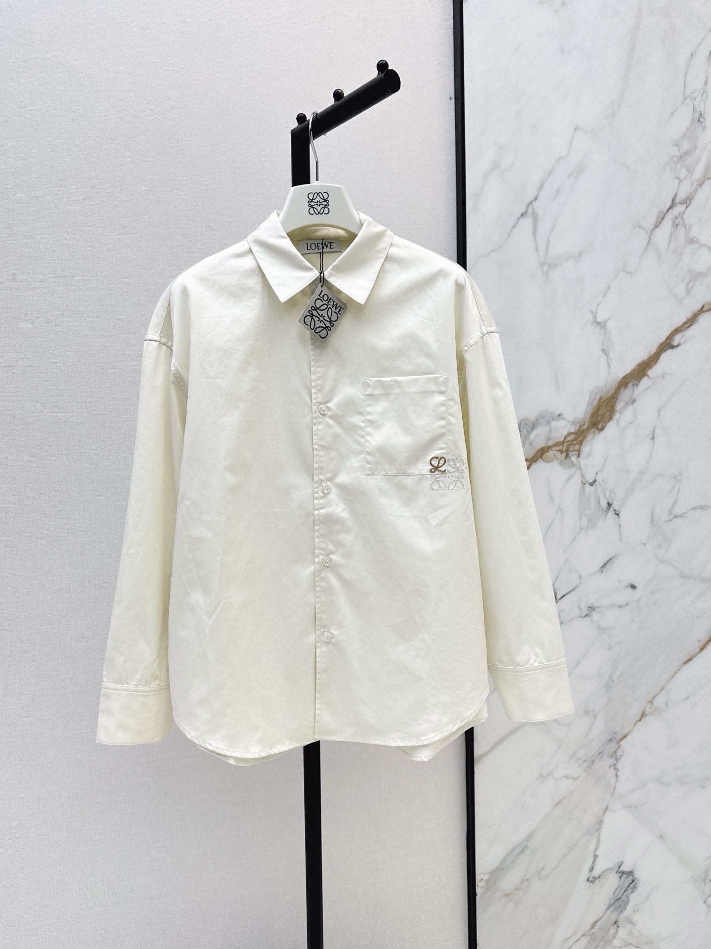 NO:934100,Loe 26Ss - the latest minimalist and relaxed-fitting beige shirt with logo embroidery in early autumn. The three-dimensional curved tailoring is not attractive. The British unisex style pocket embroidery logo is low-key and luxurious. It is versatile for commuting and super slim. The pure cotton fabric is light and comfortable. It is a high-end item that is lazy and casual. It is a shirt that can be used for commuting or daily life. One color sml,, loewe, shirts,19860909Loe 26Ss———早秋最新款极简松弛感穿搭徽标刺绣米杏色衬衫 立体弧形剪裁版型不挑人 英伦中性风口袋刺绣logo低调奢华 通勤百搭上身超显瘦 纯棉面料轻薄舒适 演绎慵懒随性的高级单品 是一件通勤或者日常兼备的衬衫 一色sml,,loewe,shirts,,Women's clothing