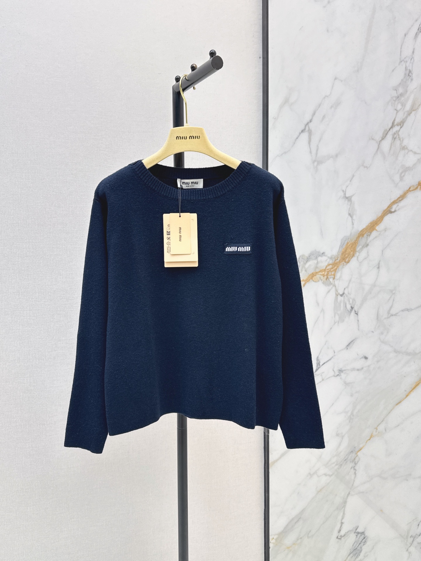 NO:934790,Miu 26Ss - the latest one-shoulder top with logo letters in early autumn. It has a super high-end texture. The blue and black upper body has a sense of luxury. The large neckline modifies the slender neck and shoulders. It has a pure and girly atmosphere. Exclusively customized imported sheep wool yarn. The classic brand white embroidered logo on the chest. Simple and recognizable. Three-dimensional tailoring, slightly wide and loose fit, easy to control for commuting and leisure. One color sml,,miumiu,19860909Miu 26Ss————早秋最新款徽标字母一字肩上衣超有高级质感的蓝黑色上身自带奢华感 大领口修饰脖颈肩膀纤细 纯欲少女气息十足 独家定制进口绵羊毛纱线 胸前经典品牌白色刺绣Logo 简约又有辨识度 立体剪裁微阔宽松版型 通勤休闲都能轻松驾驭 一色sml,,miumiu,,Women's clothing
