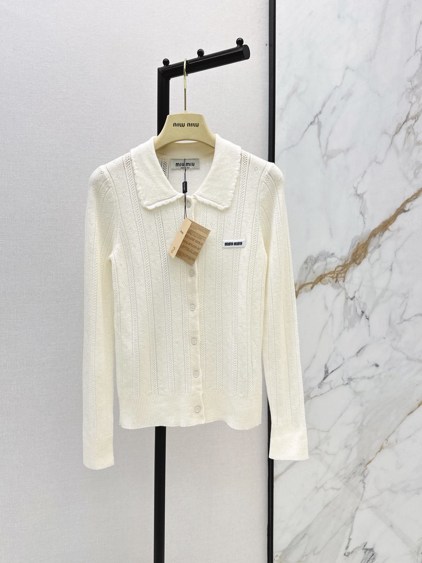 NO:944013,Miu 26Ss - the latest milky white wool knitted cardigan for early autumn. The creamy off-white wool cardigan. Heavy vertical stripe hollow texture + lace lapel design is too gentle and sweet. The lapel is single-breasted and slim fit. The classic black and white contrasting logo logo on the chest. Customized mother-of-pearl round button closure on the front. Seamless switching for sweet girls. The bottom looks great with shorts and skirts. 一色sml,,miumiu,skirts,shorts,19860909Miu 26Ss———早秋最新款奶白色白色羊毛针织开衫 奶呼呼的米白羊毛小开衫 重磅竖条镂空纹理＋花边翻领设计太温柔太甜妹 翻领单排扣修身版型 胸口饰经典黑白对比色logo徽标 前襟定制珍珠贝母圆扣开合 甜美辣妹无缝切换 下面搭配短裤小裙子都太好看了 一色sml,,miumiu,skirts,shorts,,Women's clothing