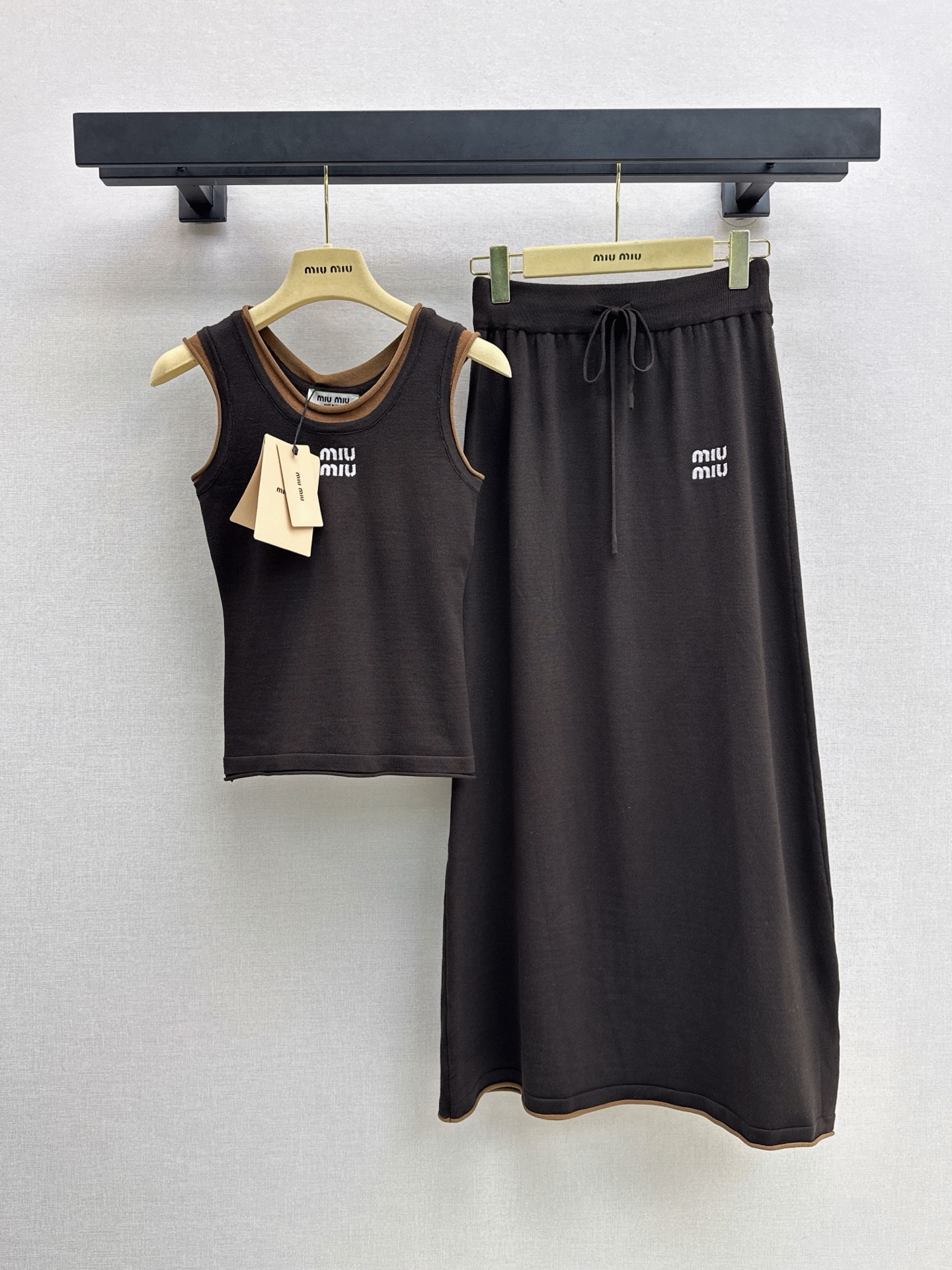 NO:946951,Miu 26Ss————The latest casual knitted suit for early autumn, fake two-piece sleeveless top + elastic waist skirt. The fabric is soft and comfortable. Vest round neck design. There is a brand logo on the chest in contrasting colors on the edge. Simple and recognizable. The overall style is unified. It is suitable for daily leisure and light sports. Comfortable and fashionable. Easily create a sense of brand atmosphere. Two-color sml,,miumiu,skirts,19860909Miu 26Ss————早秋最新款休闲针织套装假两件无袖上衣+松紧腰半裙 面料柔软舒适 背心圆领设计 边缘撞色胸前有品牌标志 简约又有辨识度 整体风格统一 日常休闲轻运动都很适合 舒适又时髦 轻松打造品牌氛围感 两色sml,,miumiu,skirts,,Women's clothing