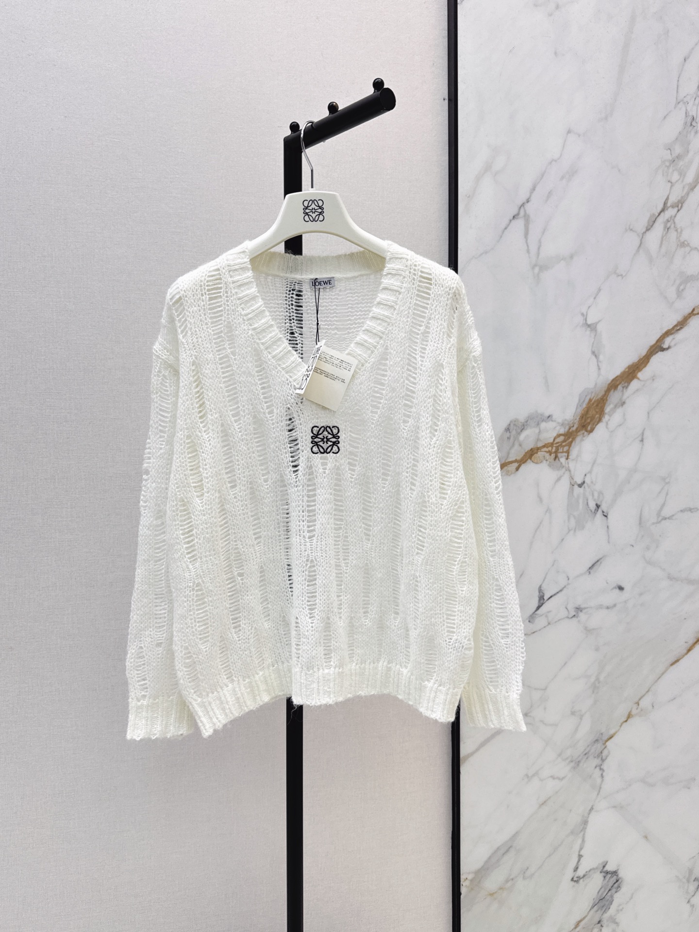 NO:956350,Loe 26Ss - the latest early autumn logo embroidery decorated hollow long-sleeved knitted top made of custom wool yarn. High-end texture. Relaxed wear. Knitted V-neck long-sleeved tailoring. The whole body is intertwined with texture to create a see-through blouse shape. It highlights the sense of high-end wear. The regular version makes the wear slimmer. The version is tolerant of the body and shows relaxation and tonality. The first choice for fashionable wear in all seasons. Three-color sml,, loewe,19860909Loe 26Ss————早秋最新款logo刺绣装饰镂空长袖针织上衣定制羊毛纱线织造 质感高级 穿搭松弛 针织V领长袖剪裁 大身通体利用肌理交织出透视罩衫造型 凸显穿搭高级感 常规版型穿搭显瘦 版型包容身材 尽显松弛调性 四季时尚穿搭首选 三色sml,,loewe,,Women's clothing