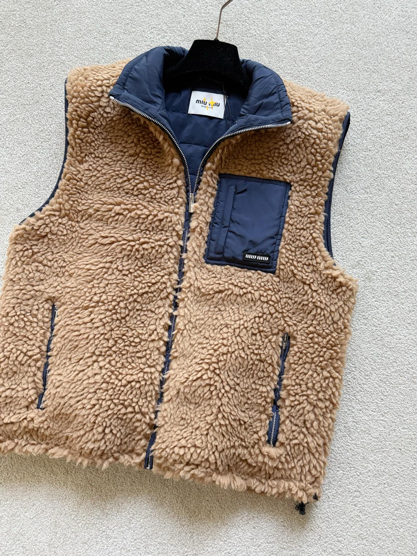 NO:709212,Equipped with a dust bag. After getting tired of wearing all kinds of down vests, miu's new product is eye-catching. The down filling on the inside is eye-catching. It is just the right balance between casual and fashionable to reduce age. Custom-woven and dyed camel lamb wool, royal blue nylon on the inside. It is filled with 90 national standard white goose down that can pass the inspection, and the filling amount is 35 grams. The polar fleece texture on the surface is evenly processed. It is very warm and easier to take care of in daily life. Small logo zipper and small details. All possible details are taken into consideration.  Can be worn alone or layered,,miumiu,down jacket,19860909配防尘袋穿腻了各类羽绒马甲,miu新品 羊羔毛内里羽绒填充让人眼前一亮 休闲和时髦减龄兼顾得刚刚好 定织定染驼色羊羔毛,内里皇家蓝尼龙 填充90国标可过检白鹅绒,充绒量35克 表面摇粒绒质感处理均匀得当 保暖度十足,日常也更加方便打理 小徽标加拉链小细节 能考虑的细节都考虑到 单穿或者叠穿都可,,miumiu,down jacket,,Women's clothing