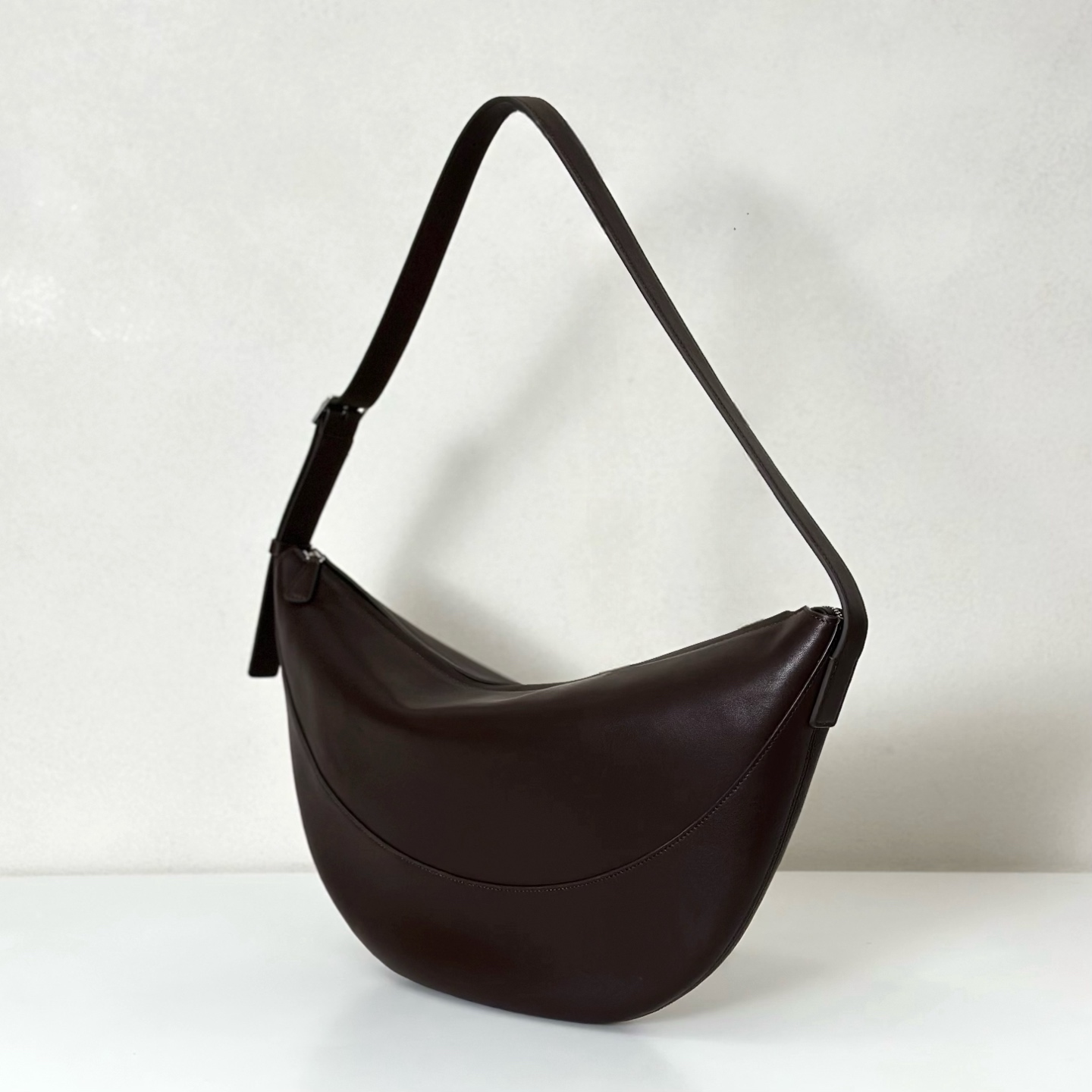 p1090。Jouve Bag 咖啡平纹（w1772）

尺寸:长45.5cmX宽3cmX高24.5cm

新月形斜挎包，包面采用光滑轻质纳帕皮革制成，内里羊皮，触感柔软极佳！配有拉链开合和带金属扣的可调节肩带。