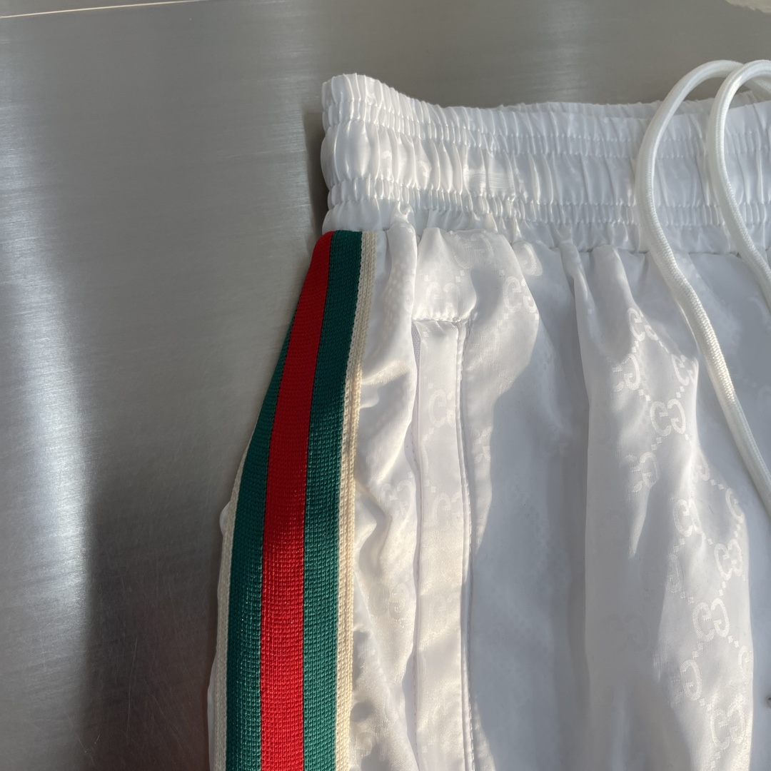 -GUCC 彩边休闲沙滩短裤，这款短裤采用双GG提花面料制作，腰头有松紧腰绳，两个口袋配有拉链，裤腿侧边