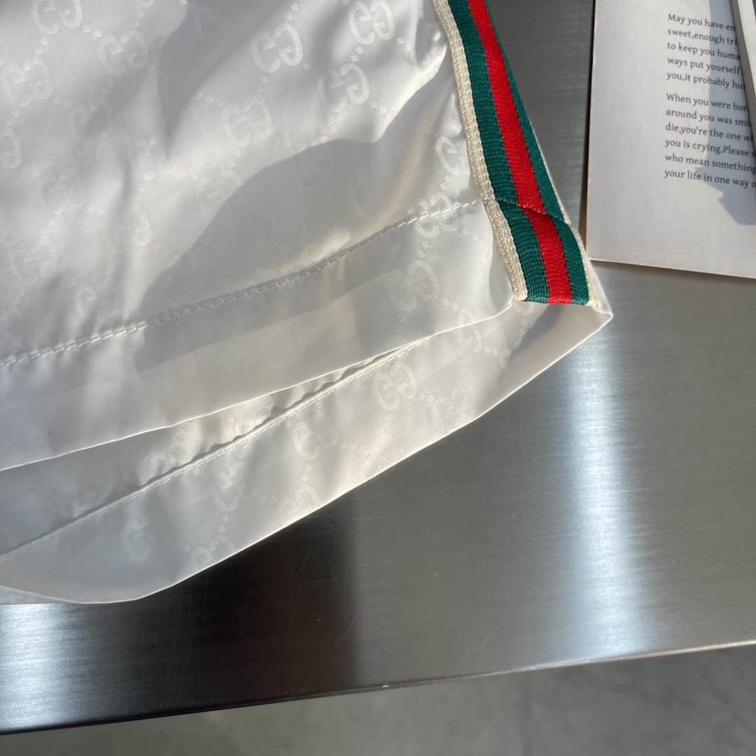 -GUCC 彩边休闲沙滩短裤，这款短裤采用双GG提花面料制作，腰头有松紧腰绳，两个口袋配有拉链，裤腿侧边