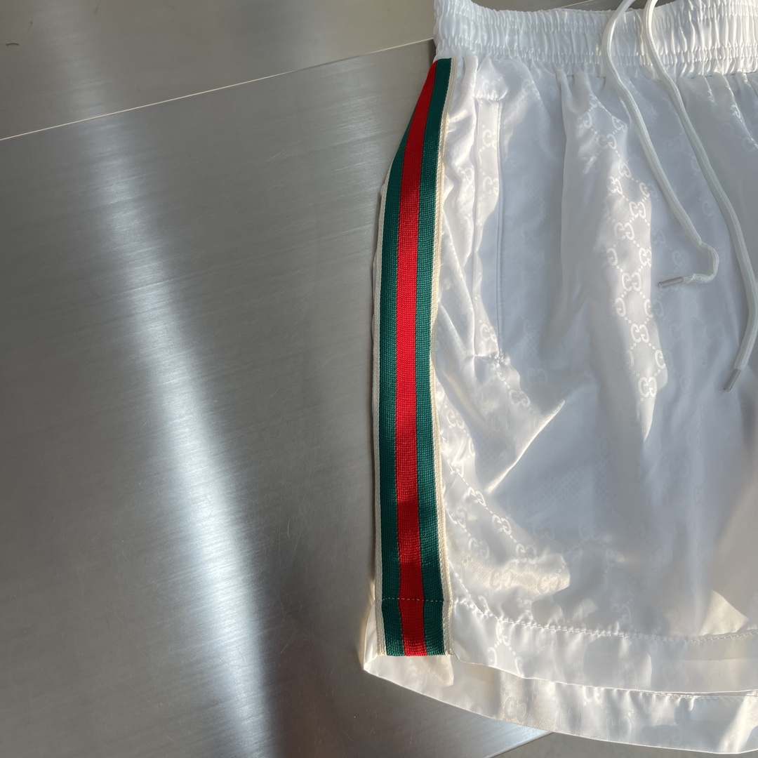 -GUCC 彩边休闲沙滩短裤，这款短裤采用双GG提花面料制作，腰头有松紧腰绳，两个口袋配有拉链，裤腿侧边