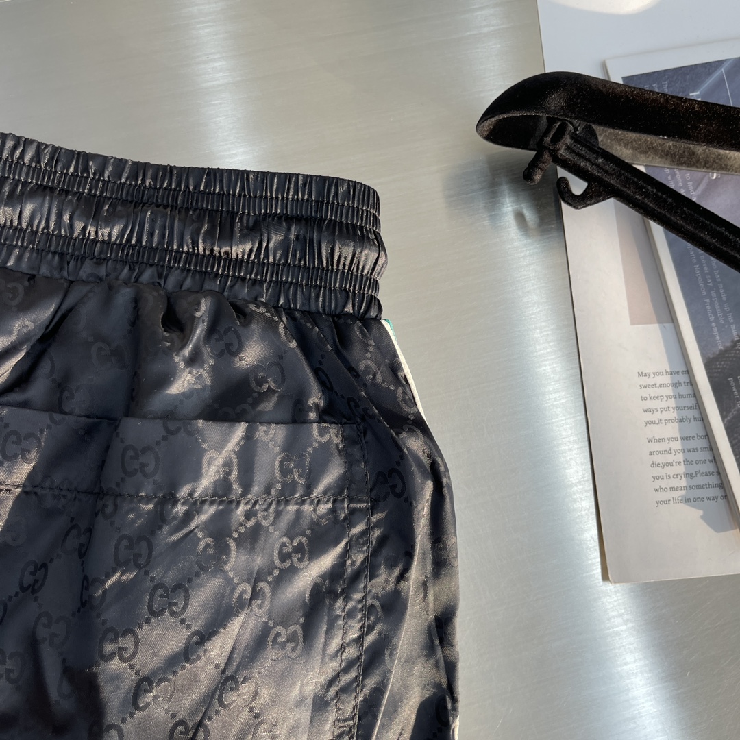 -GUCC 彩边休闲沙滩短裤，这款短裤采用双GG提花面料制作，腰头有松紧腰绳，两个口袋配有拉链，裤腿侧边