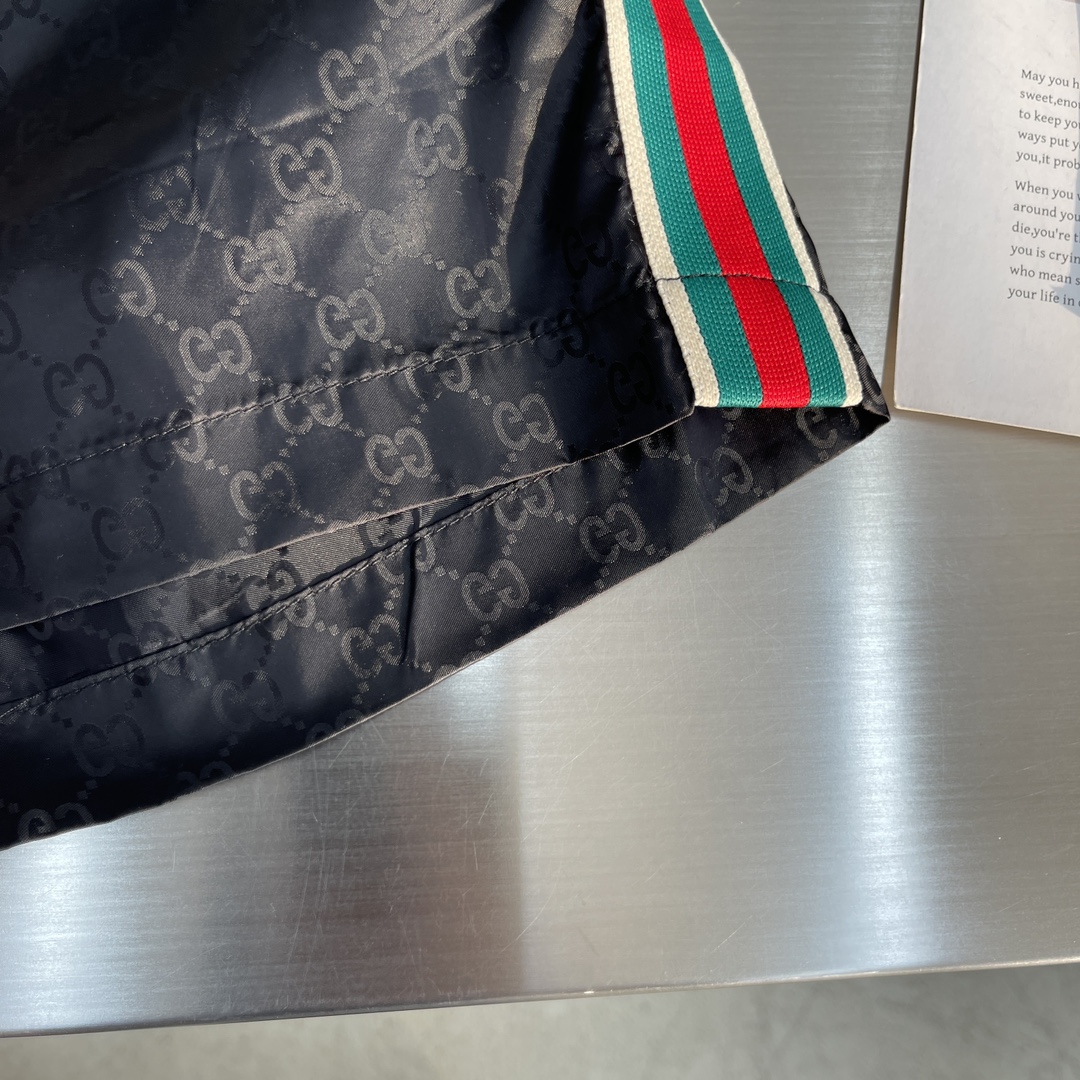 -GUCC 彩边休闲沙滩短裤，这款短裤采用双GG提花面料制作，腰头有松紧腰绳，两个口袋配有拉链，裤腿侧边