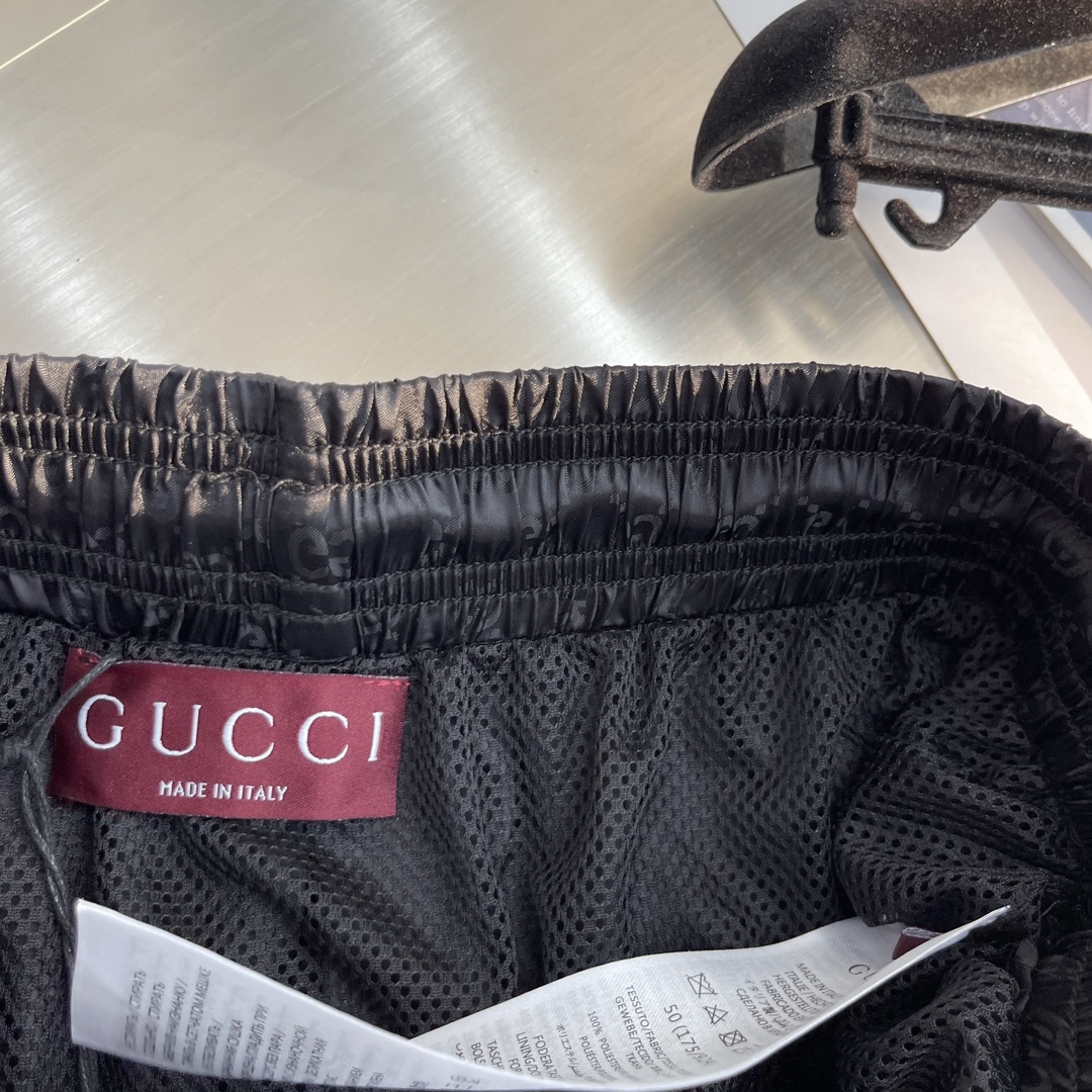 -GUCC 彩边休闲沙滩短裤，这款短裤采用双GG提花面料制作，腰头有松紧腰绳，两个口袋配有拉链，裤腿侧边