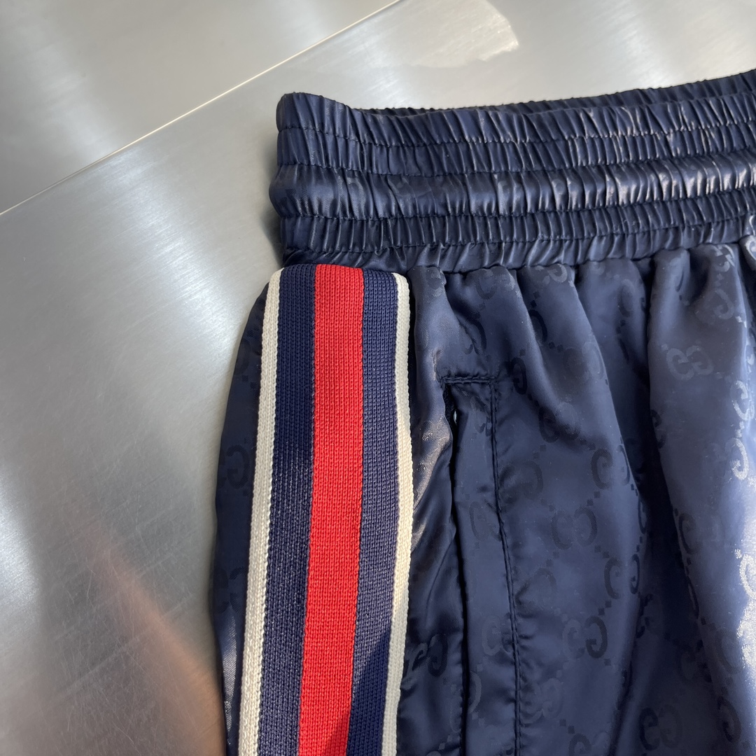 -GUCC 彩边休闲沙滩短裤，这款短裤采用双GG提花面料制作，腰头有松紧腰绳，两个口袋配有拉链，裤腿侧边