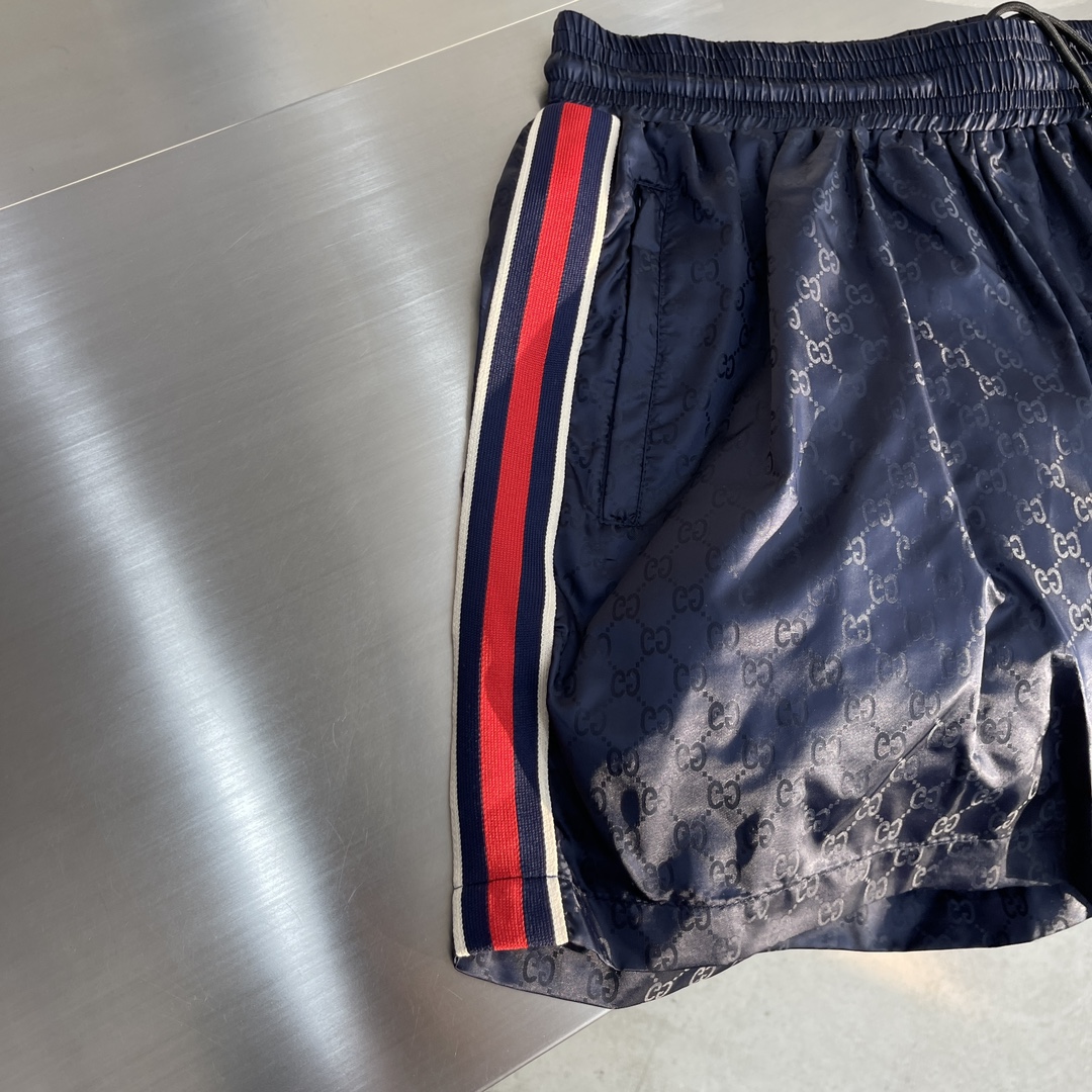-GUCC 彩边休闲沙滩短裤，这款短裤采用双GG提花面料制作，腰头有松紧腰绳，两个口袋配有拉链，裤腿侧边