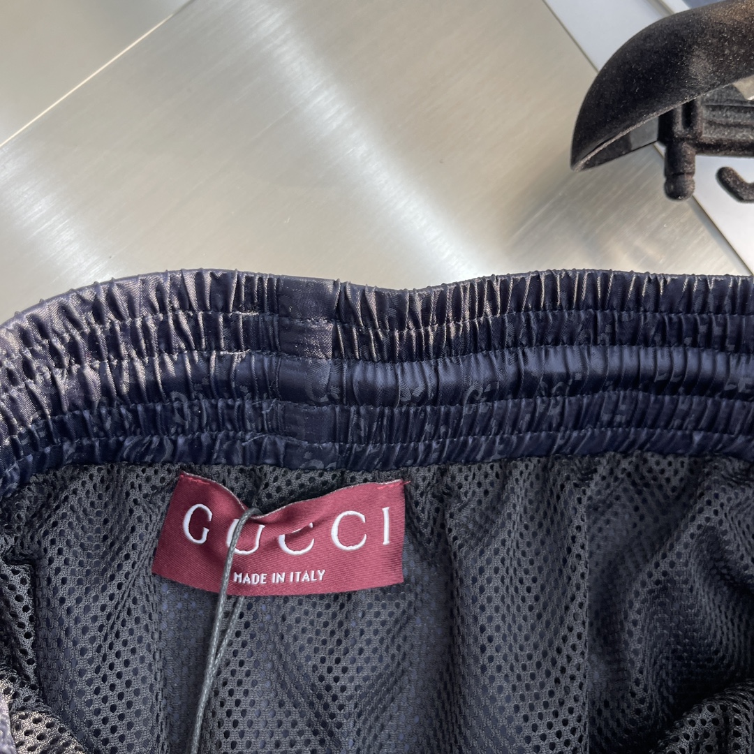 -GUCC 彩边休闲沙滩短裤，这款短裤采用双GG提花面料制作，腰头有松紧腰绳，两个口袋配有拉链，裤腿侧边