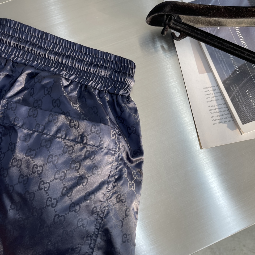 -GUCC 彩边休闲沙滩短裤，这款短裤采用双GG提花面料制作，腰头有松紧腰绳，两个口袋配有拉链，裤腿侧边