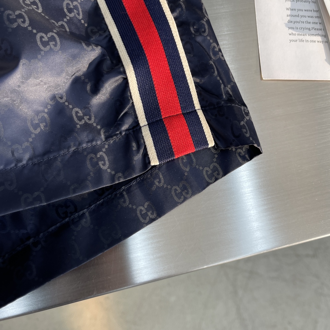 -GUCC 彩边休闲沙滩短裤，这款短裤采用双GG提花面料制作，腰头有松紧腰绳，两个口袋配有拉链，裤腿侧边