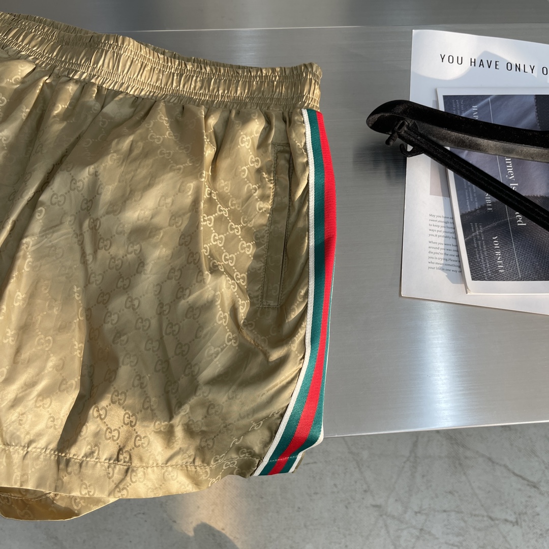 -GUCC 彩边休闲沙滩短裤，这款短裤采用双GG提花面料制作，腰头有松紧腰绳，两个口袋配有拉链，裤腿侧边