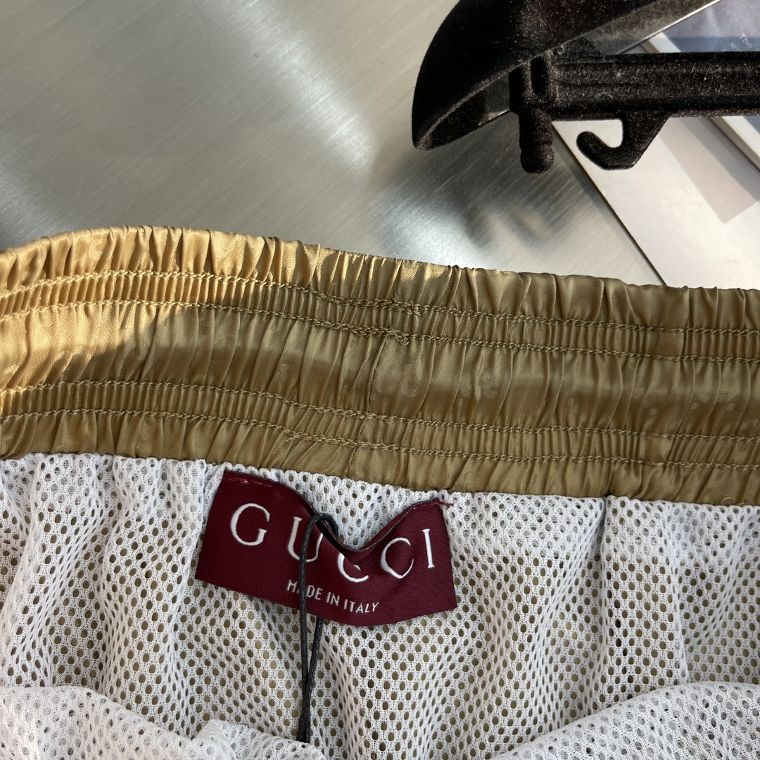 -GUCC 彩边休闲沙滩短裤，这款短裤采用双GG提花面料制作，腰头有松紧腰绳，两个口袋配有拉链，裤腿侧边