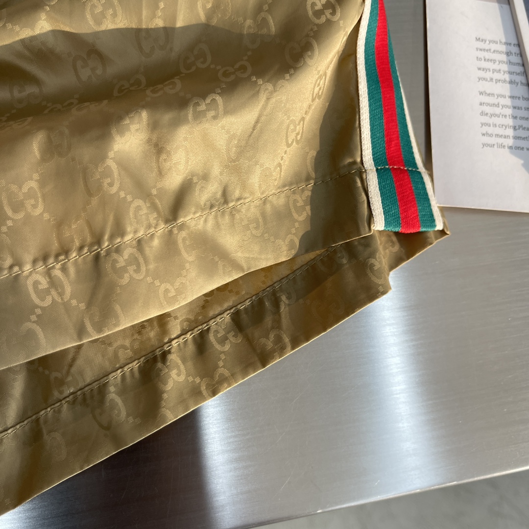 -GUCC 彩边休闲沙滩短裤，这款短裤采用双GG提花面料制作，腰头有松紧腰绳，两个口袋配有拉链，裤腿侧边