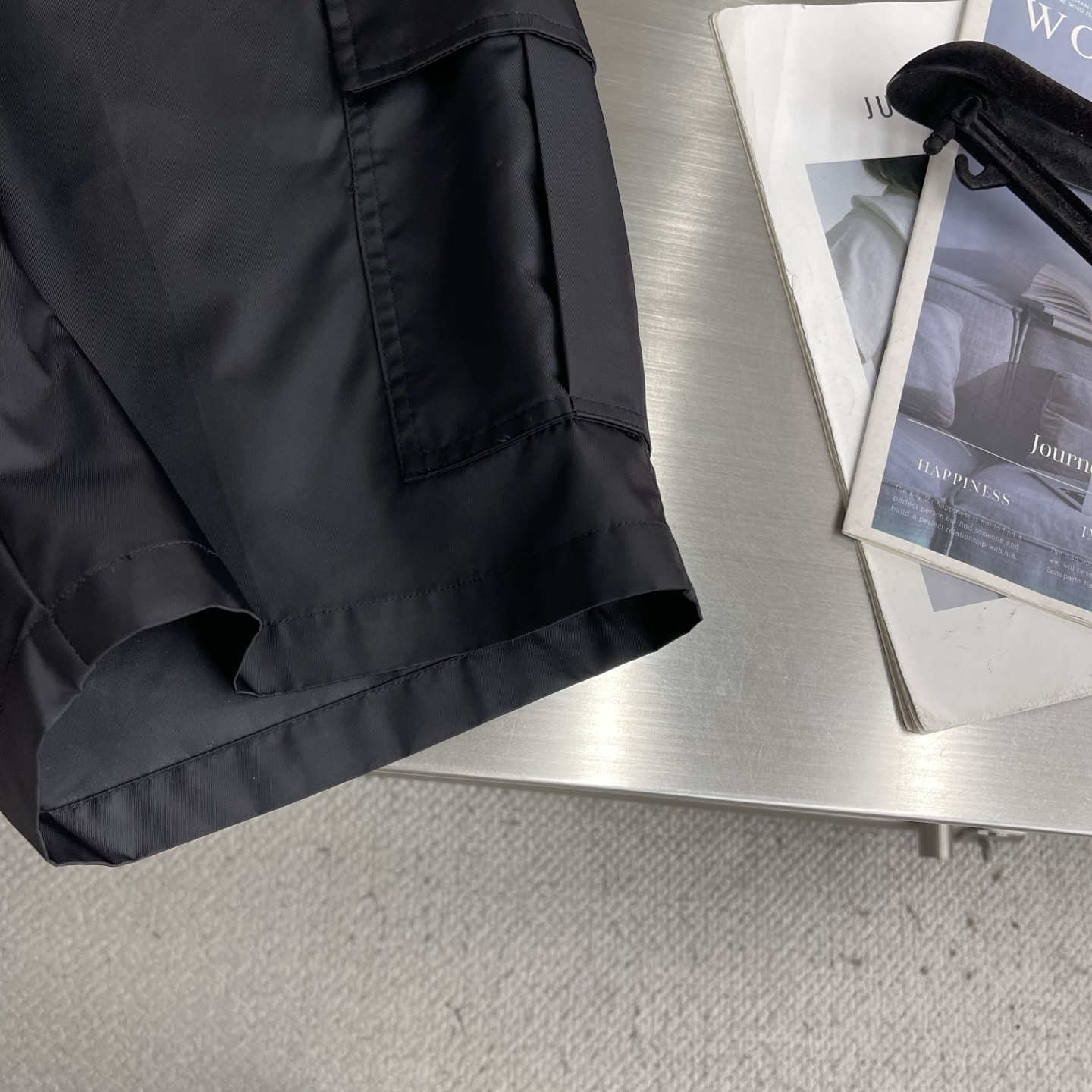 -PRAD 尼龙工装短裤选用标志性尼龙面料制成，通过高密度的编织结构，使其具备高强度抗撕裂，耐磨性超群。