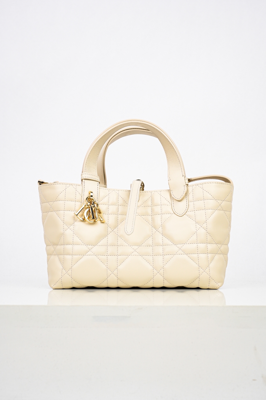 本地自取💰950  支持放店
CD 迪奥toujours 滕格纹牛皮革土著包手提包  象牙白
24秋冬系列发布秀精彩亮相，休闲实用的设计别具一格。
采用黑色牛皮革精心制作，宽敞的内部隔层搭配小袋，可整齐收纳各种日常用品。

设有皮革系带开合，可安全收纳各种物品，另有CD Lock 字母 D旋钮式开合，可调节两侧，提升格调。

皮革手柄带有可调节细节，可手提或肩背