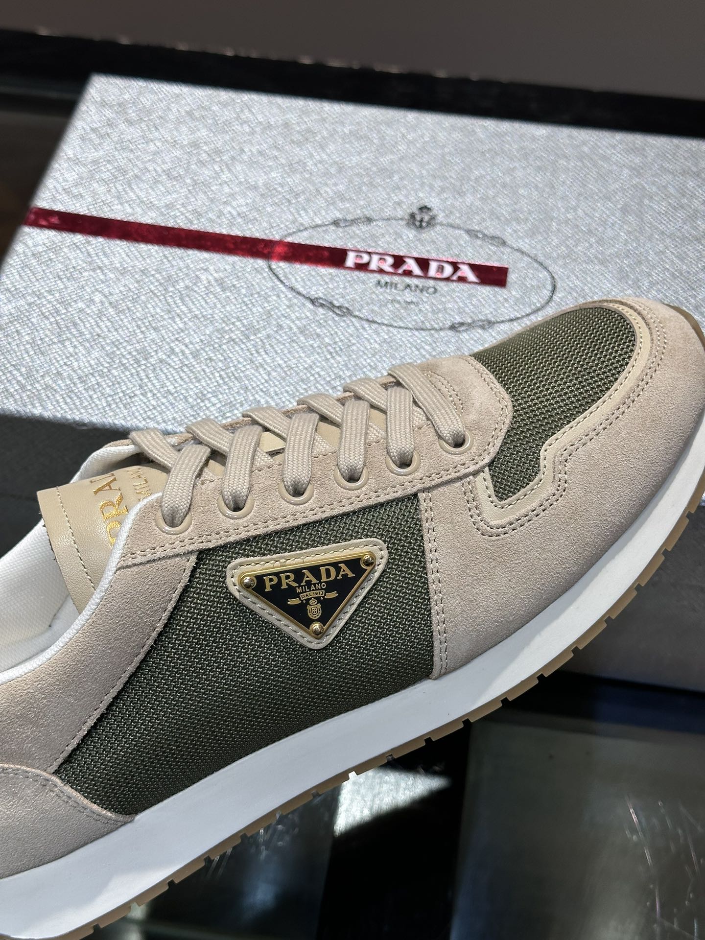 Prada/普拉达男士新款运动休闲鞋这款运动鞋鞋面采用进口小牛皮拼接透气网面外侧饰以P家经典金属三角珐琅