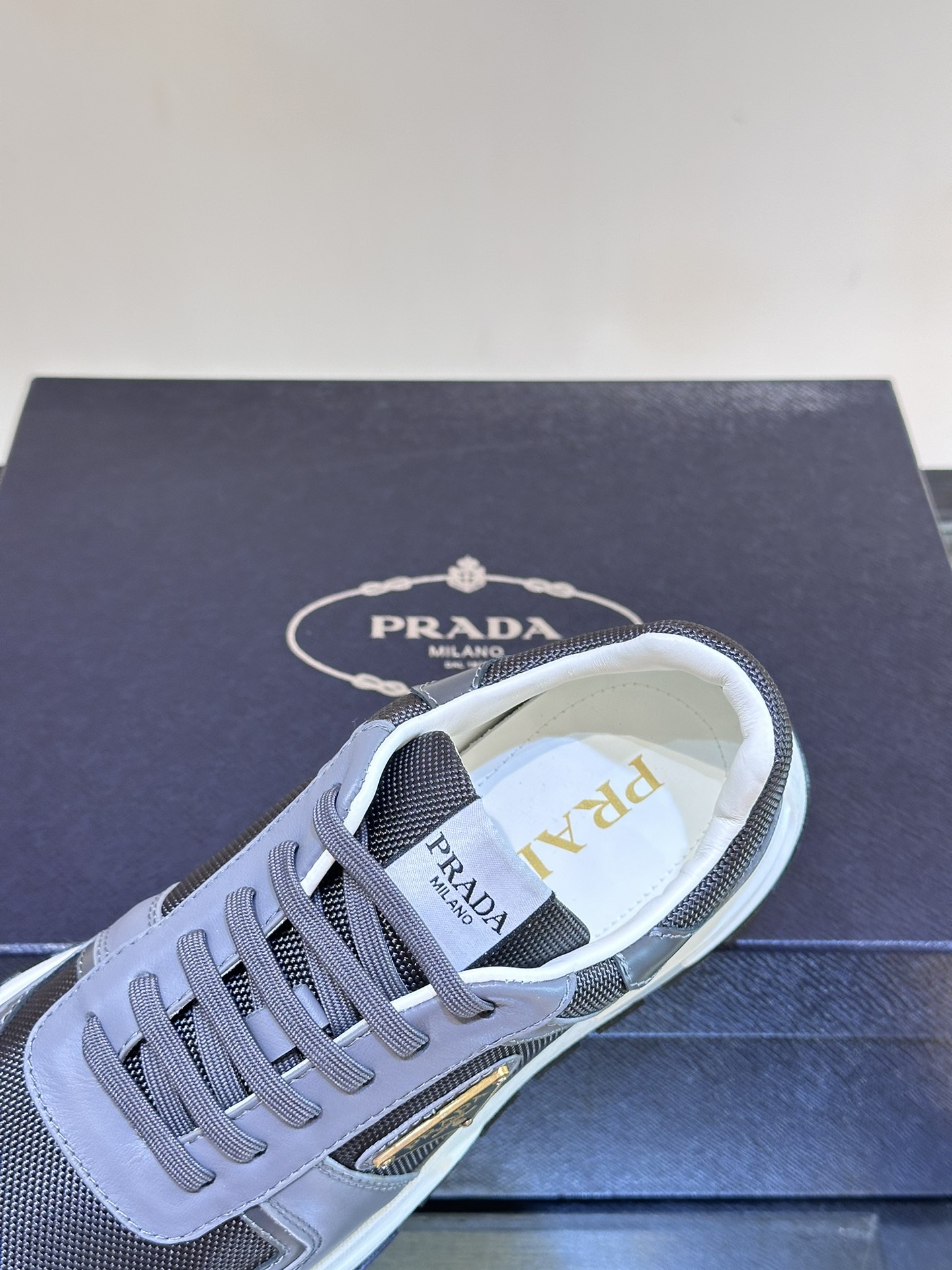 Prada/普拉达男士新款运动休闲鞋这款运动鞋鞋面采用进口小牛皮拼接透气网面外侧饰以P家经典金属三角珐琅