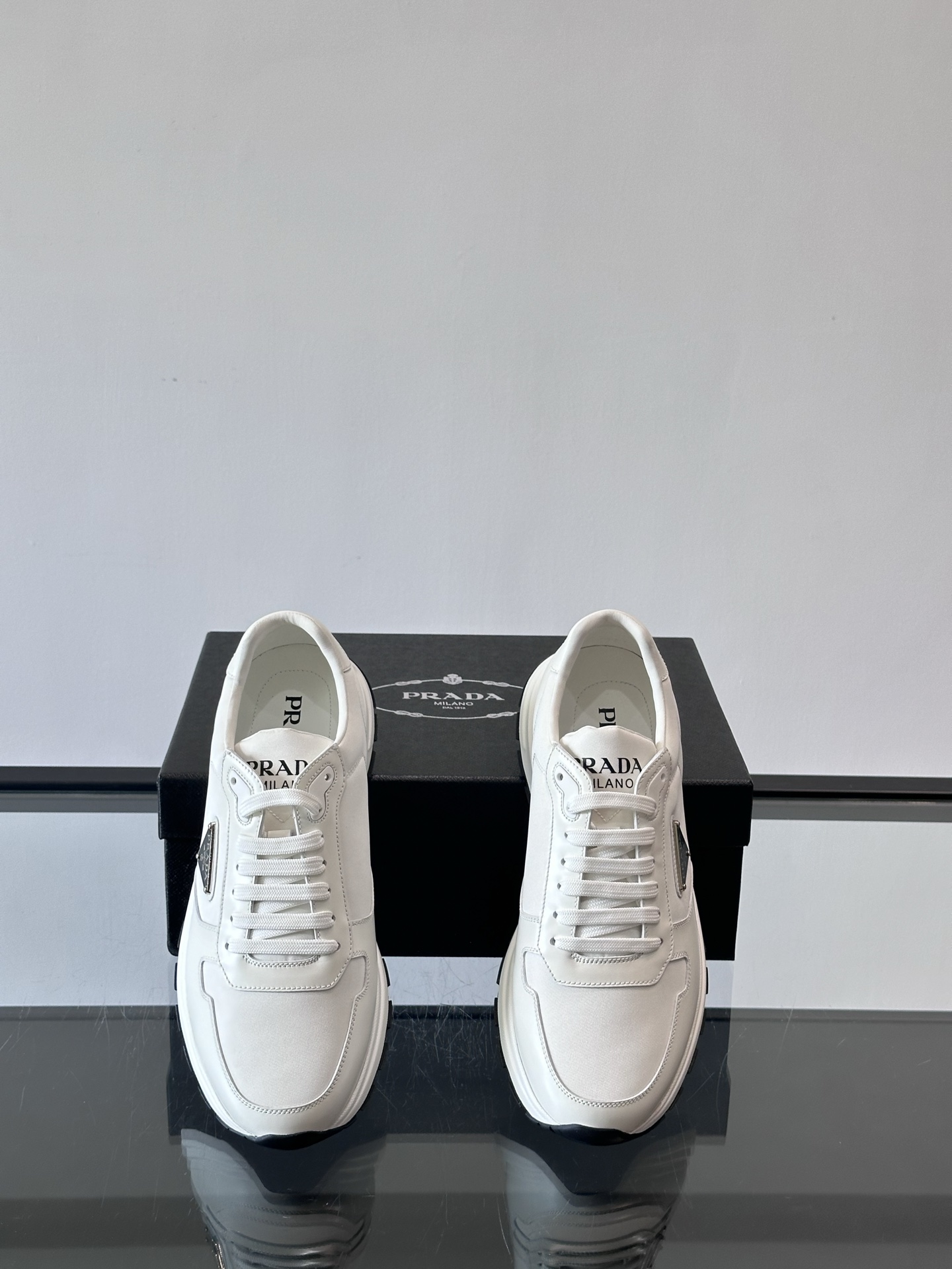 Prada/普拉达 男士新款运动休闲鞋，这款运动鞋鞋面采用进口小牛皮。外侧饰以P家经典金属三角珐琅徽标，