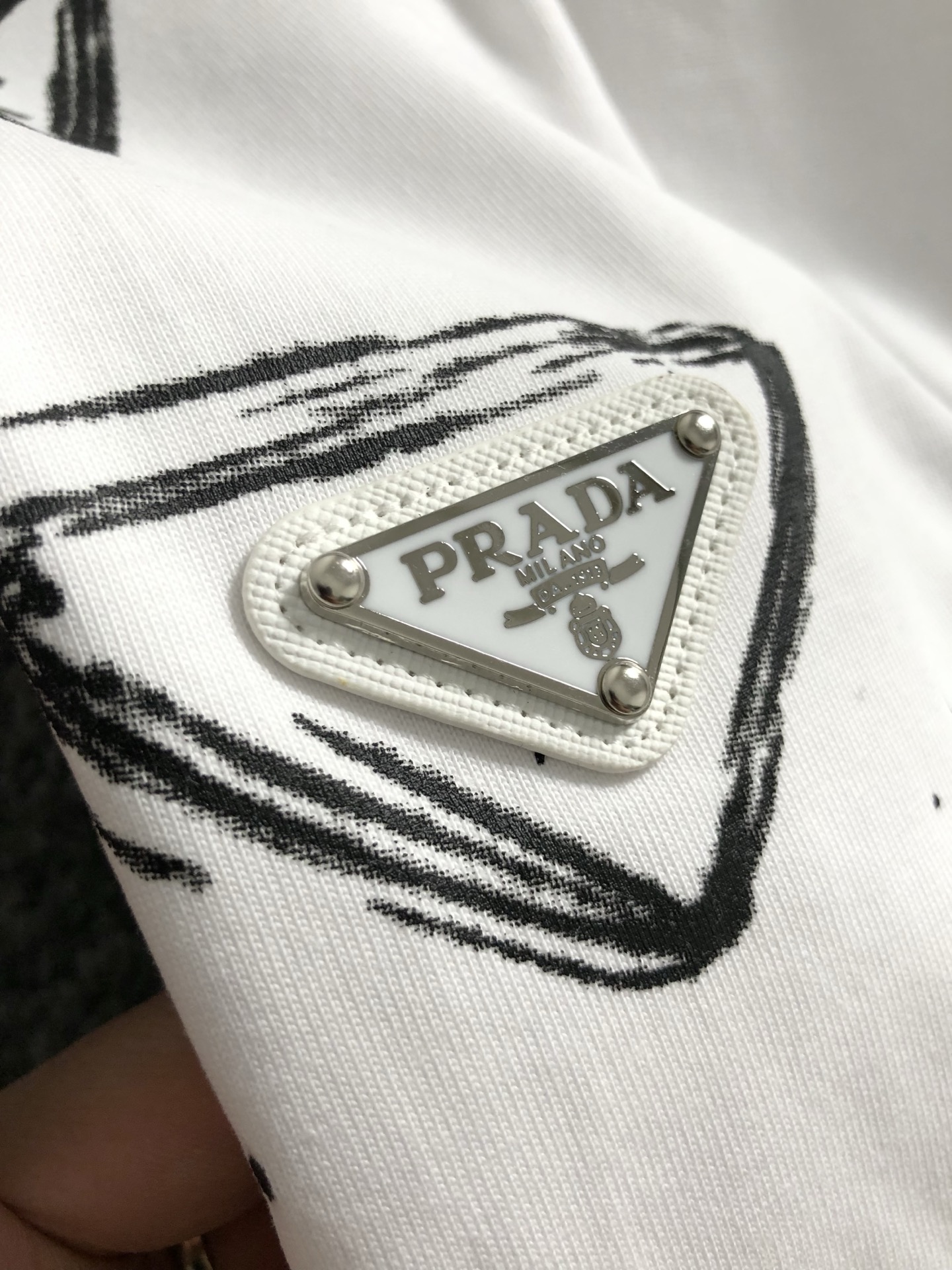  Prad*合身版型S-Xl
25春夏顶编金属三角标涂鸦重工工艺潮牌短袖，精致工艺专柜面料，顶级元素融合