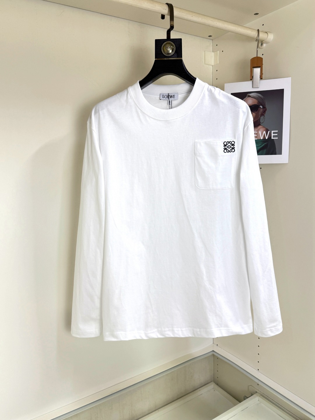 NO:526745,LOEWE 2025 Autumn and Winter 2025 round neck embroidered long-sleeved T-shirt base shirt. The elemental logo badge highlights the casual and fashionable charm, and is still unique in the fashion style. Selected long velvet cotton yarn, 260g worsted high-split heavy-duty fixed-woven fixed-dyed fabric, high-temperature washing before cutting, and the finished product is soft, and the dress feels skin-friendly and cotton soft, with natural drape. The counter is synchronized, with a slightly shoulder-falling loose style, which can be salty or sweet, both for men and women, and is super versatile. It uses instrument embroidery, and the delicate and full texture highlights, bringing a new experience to fashion sports and leisure!  !  Size XS-XL XS Size Shoulder Width 48 Bust 100 Clothes Length 68 S S S Shoulder Width 50 Bust 104 Clothes Length 70 M S Shoulder Width 52 Bust 108 Clothes Length 72 L Size Shoulder Width 54 Bust 112 Clothes Length 74 XL Size Shoulder Width 56 Bust 116 Clothes Length 76,,loewe,loewe,tees,t-shirt,alexander wang19860909LOEWE罗意威 2025秋冬 圆领刺绣长袖T恤打底衫 元素性的Logo徽章凸显休闲时尚魅力,依然独领时尚风骚,甄选长绒棉纱,260g精纺高支重磅定织定染面料,裁前高温洗水定型,成品再洗柔,穿着感受亲肤棉柔,垂感自然.专柜同步,微落肩宽松版型,可盐可甜,男女皆宜,超百搭. 采用器械刺绣,细腻饱满的质感突显,为时尚运动休闲带来全新体验！！ 尺码 XS-XL XS码肩宽48 胸围100 衣长68 S码肩宽50 胸围104 衣长70 M码肩宽52 胸围108 衣长72 L码肩宽54 胸围112 衣长74 XL码肩宽56 胸围116 衣长76,,loewe,loewe,tees，t-shirt,alexander wang,Men's clothing