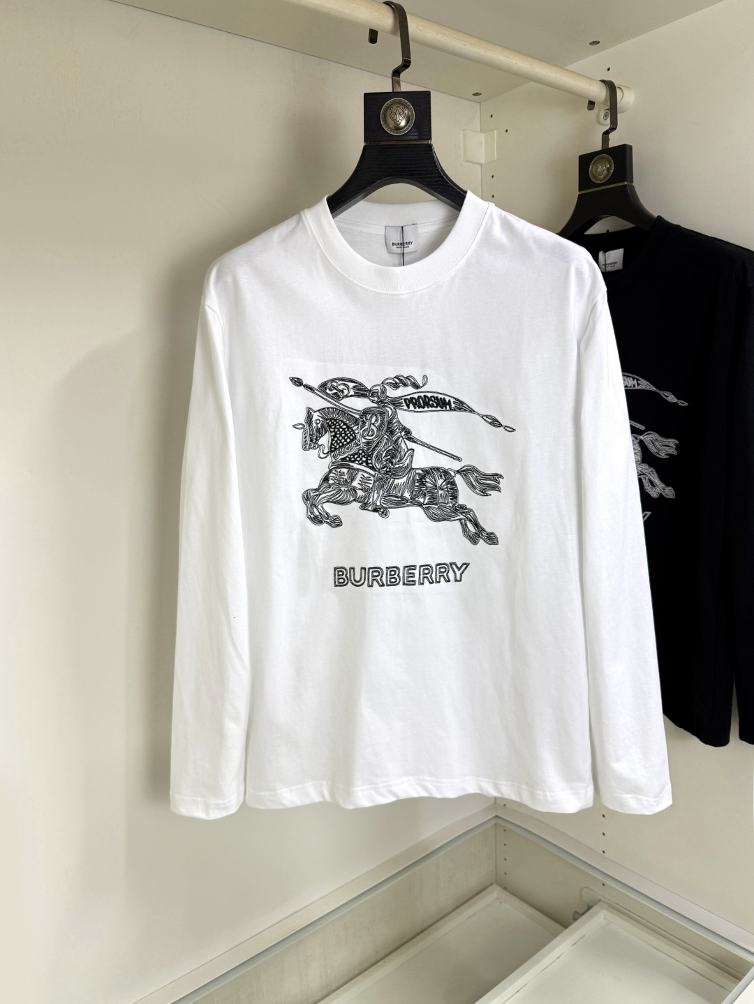 NO:681444,Burberry 2025 Autumn and Winter round neck embroidered long-sleeved T-shirt base layer. The elemental logo badge highlights the casual fashion charm and still leads the fashion trend. It selects long-staple cotton yarn and 260g worsted high-count heavy-weight custom-woven and dyed fabrics. It is washed at high temperature before cutting to set the shape. The finished product is washed softly. It feels skin-friendly when worn. The cotton is soft and has a natural drape. It is synchronized with the counter and has a loose version with slightly dropped shoulders. It can be salty or sweet, suitable for both men and women, and is super versatile.  Using machine embroidery, the delicate and full texture is highlighted, bringing a new experience to fashion sports and leisure!  !  Sizes XS-XL19860909Burberry 巴宝莉 2025秋冬 圆领刺绣长袖T恤打底衫 元素性的Logo徽章凸显休闲时尚魅力,依然独领时尚风骚,甄选长绒棉纱,260g精纺高支重磅定织定染面料,裁前高温洗水定型,成品再洗柔,穿着感受亲肤棉柔,垂感自然.专柜同步,微落肩宽松版型,可盐可甜,男女皆宜,超百搭. 采用器械刺绣,细腻饱满的质感突显,为时尚运动休闲带来全新体验！！ 尺码 XS-XL XS码肩宽48 胸围100 衣长68 S码肩宽50 胸围104 衣长70 M码肩宽52 胸围108 衣长72 L码肩宽54 胸围112 衣长74 XL码肩宽56 胸围116 衣长76,,burberry,burberry,tees，t-shirt,,Men's clothing