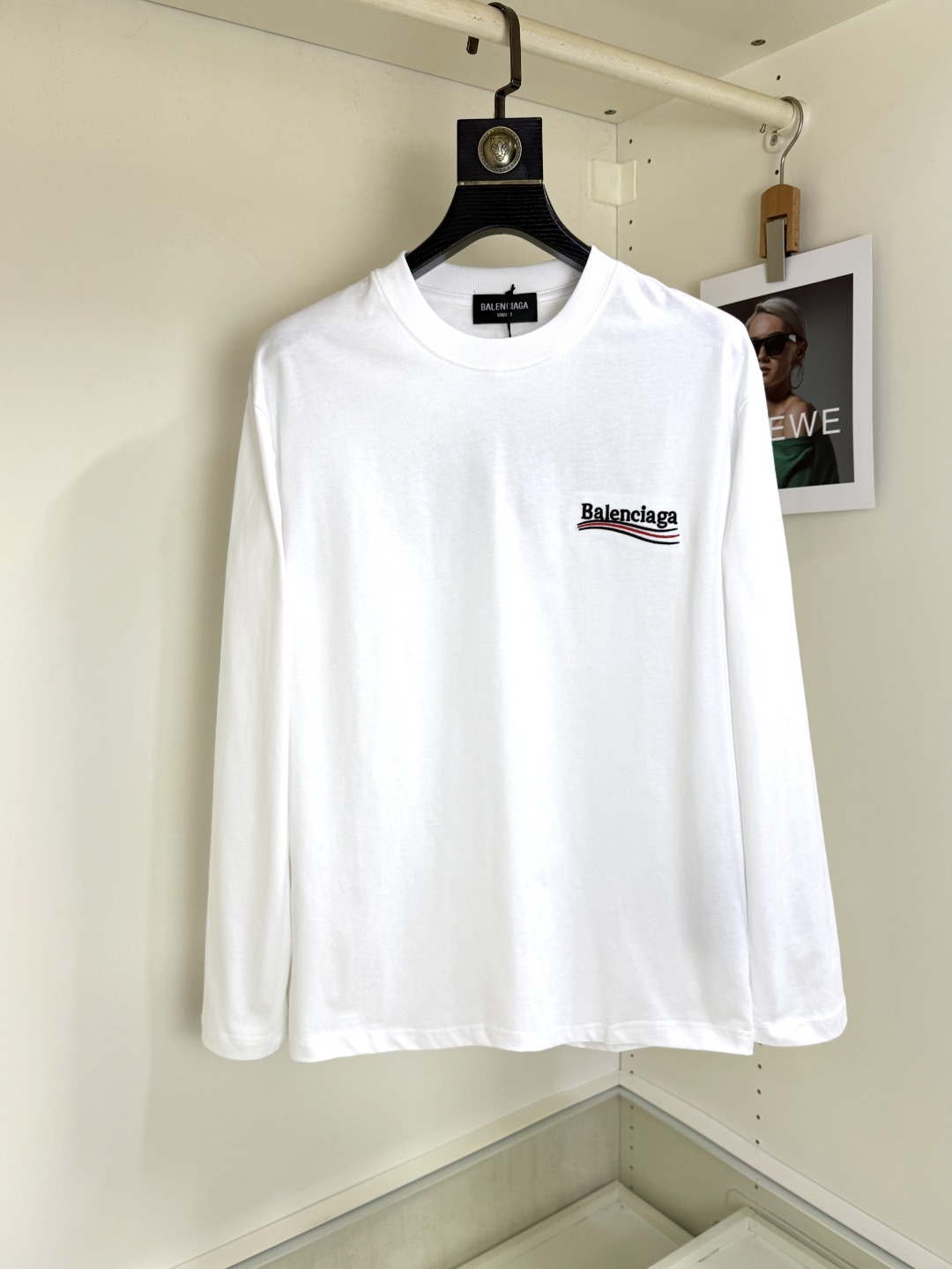 NO:775500,Balenciaga 2025 Autumn and Winter round neck long-sleeved T-shirt base layer. The elemental logo badge highlights the casual fashion charm and still leads the fashion style. It selects long-staple cotton yarn and 260g worsted high-count heavy-weight custom-woven and dyed fabrics. It is washed at high temperature before cutting to set the shape. The finished product is washed softly. It feels skin-friendly when worn. The cotton is soft and has a natural drape. It is synchronized with the counter and has a loose version with slightly dropped shoulders. It can be salty or sweet, suitable for both men and women, and is super versatile.  Using machine embroidery, the delicate and full texture is highlighted, bringing a new experience to fashion sports and leisure!  !  Sizes XS-XL19860909Balenciaga 巴黎世家 2025秋冬 圆领长袖T恤打底衫 元素性的Logo徽章凸显休闲时尚魅力,依然独领时尚风骚,甄选长绒棉纱,260g精纺高支重磅定织定染面料,裁前高温洗水定型,成品再洗柔,穿着感受亲肤棉柔,垂感自然.专柜同步,微落肩宽松版型,可盐可甜,男女皆宜,超百搭. 采用器械刺绣,细腻饱满的质感突显,为时尚运动休闲带来全新体验！！ 尺码 XS-XL XS码肩宽48 胸围100 衣长68 S码肩宽50 胸围104 衣长70 M码肩宽52 胸围108 衣长72 L码肩宽54 胸围112 衣长74 XL码肩宽56 胸围116 衣长76,,balenciaga,balenciaga,tees，t-shirt,,Men's clothing