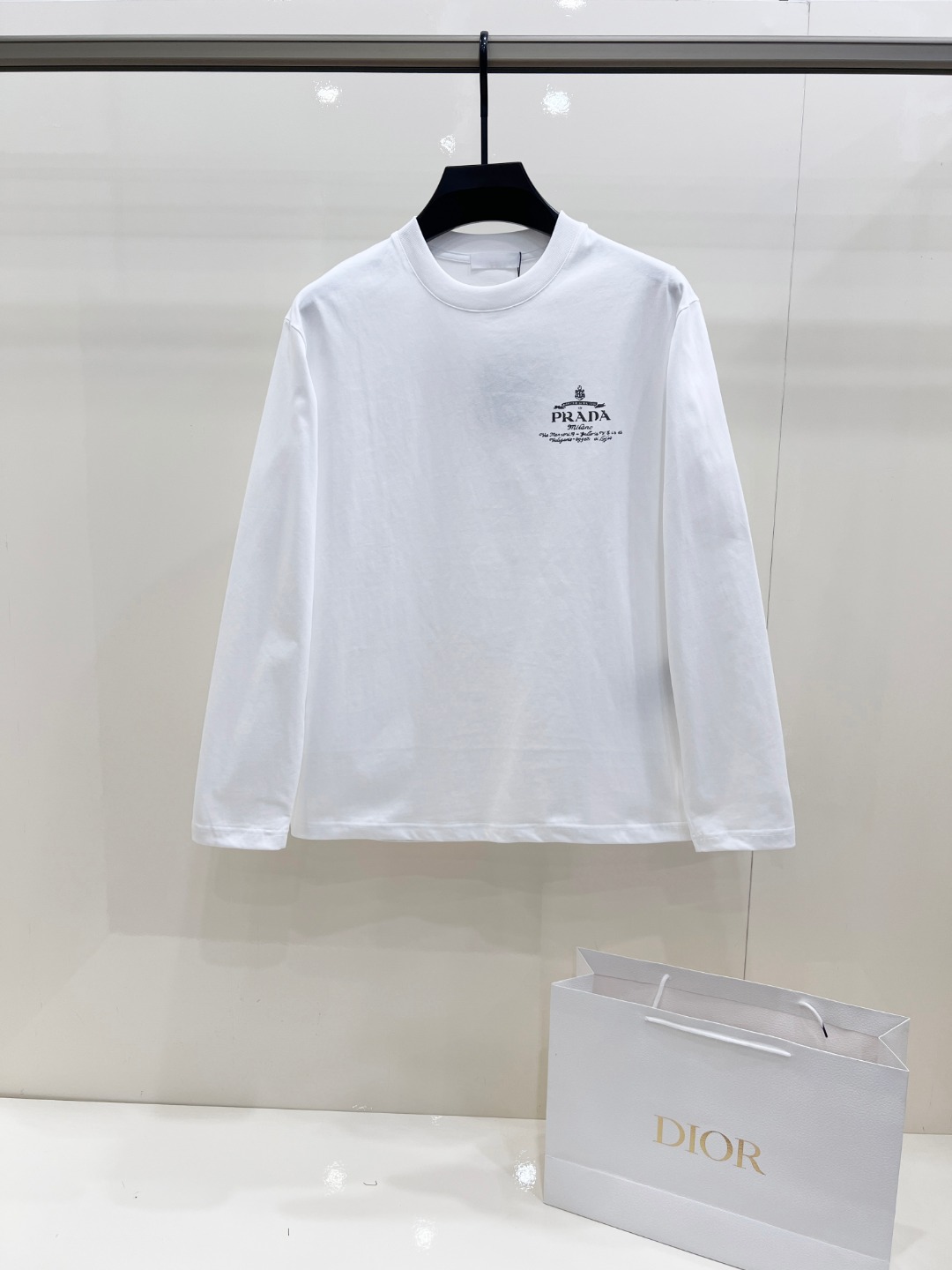 NO:684632,Prada Classic round neck long-sleeved T-shirt, available in white and black. The fabric is made of high-quality pure cotton, soft and comfortable to the touch, loose and dropped shoulders, simple and elegant. Small logo print design on the chest, large letter print embellishment on the back, exquisite details. Complete three standards, exquisite workmanship. Outstanding upper body effect, versatile and fashionable. Suitable for daily wear, business casual, leisure sports and other occasions. Sizes XS-XL XS shoulder width 48, bust 100, length 68  Size S, shoulder width 50, chest size 104, length 70, size M, shoulder width 52, chest size 108 length, 72 size L, shoulder width 54, size chest 112, length 74, size XL, size shoulder width 56, chest size 116, length 76, prada, prada, tees, t-shirt,19860909Prada 普拉达 经典圆领长袖T恤,白色和黑色两款可选.面料采用优质纯棉,手感柔软舒适,版型宽松落肩,简约大气.胸前小logo印花设计,背后大字母印花点缀,细节精致.三标齐全,做工精湛. 上身效果出众,百搭时尚.适合日常穿搭、商务休闲、休闲运动等多种场合. 尺码 XS-XL XS码肩宽48 胸围100 衣长68 S码肩宽50 胸围104 衣长70 M码肩宽52 胸围108 衣长72 L码肩宽54 胸围112 衣长74 XL码肩宽56 胸围116 衣长76,,prada,prada,tees，t-shirt,,Men's clothing