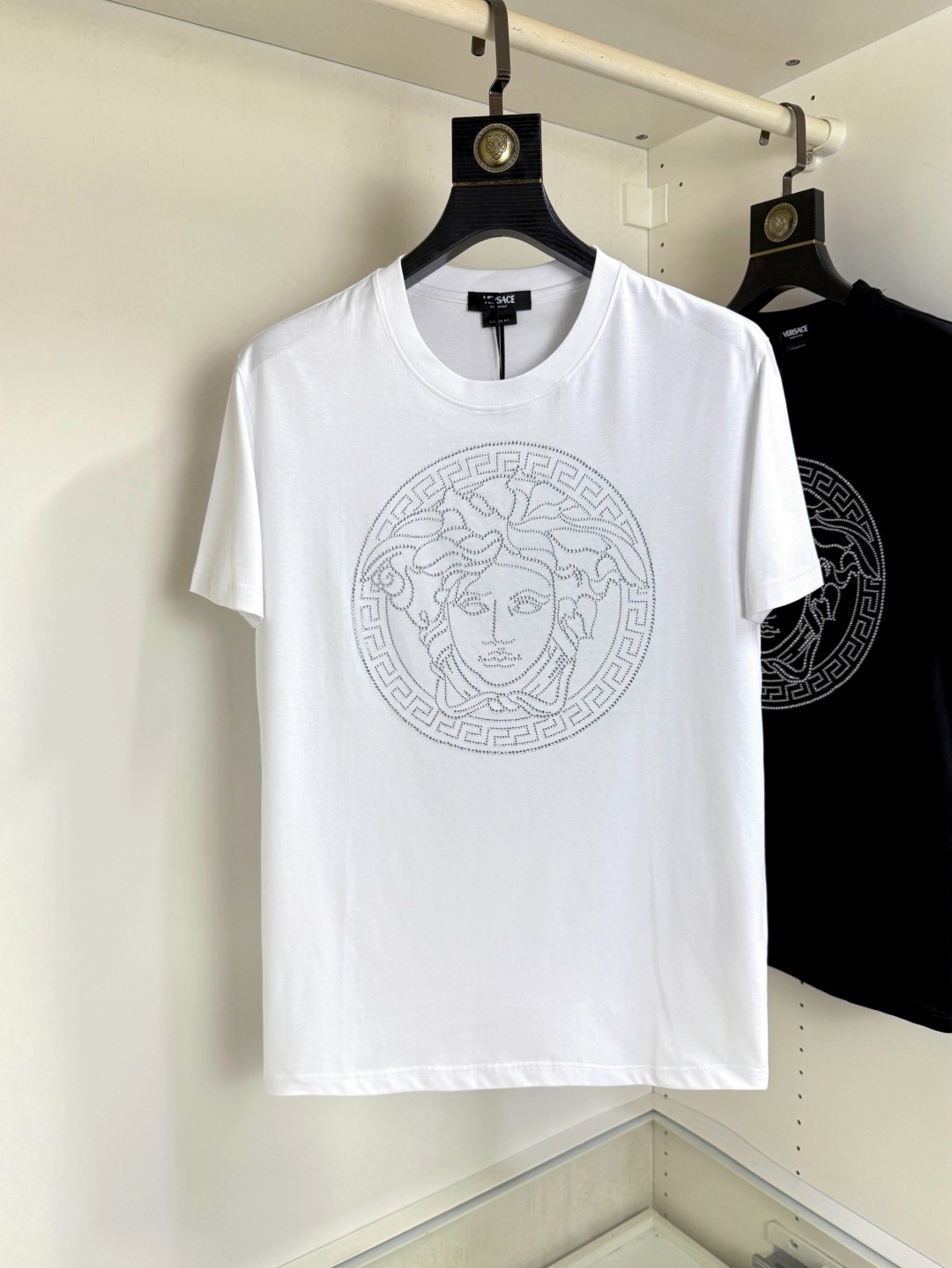 NO:847142,Versace's new summer heavy-duty rhinestone Medusa round-neck short-sleeved T-shirt, the latest synchronization, creates a basic men's item and injects new ideas into the men's wardrobe. Made of soft cotton double-sided knitted long-staple cotton + modal cotton fabric, the fabric is fine, soft and drapey, full of cotton feel, excellent upper body comfort, and not easy to deform after long-term wear and washing; color black white code size M～4XL,,versace,versace,T-shirt,tees,t-shirt,19860909Versace 范思哲 夏季新品重工水钻Medusa圆领短袖T恤,最新同步,打造男士基本款单品,为男士衣橱注入新意.采用柔软棉质双面针织长绒棉+莫代尔棉面料制成,面料细腻、柔感垂顺、棉感十足、上身舒适度极佳,久穿久洗不易变形；颜色黑色 白色 码数M～4XL,,versace,versace,T-shirt,tees，t-shirt,,Men's clothing