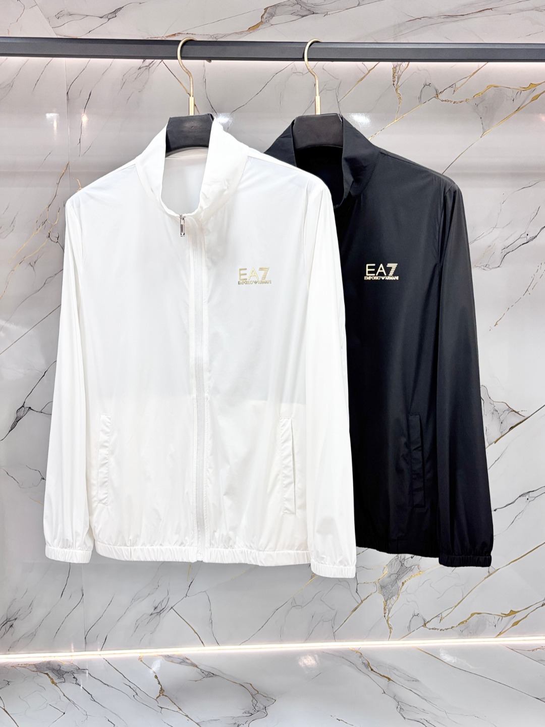 NO:903591,Armani Armani's new spring and summer men's sun protection clothing is a lightweight jacket. It is made of uniquely customized sun protection four-way elastic fabric. It has excellent elasticity and resilience and four-way stretch. The fabric is elastic in the warp and weft, transverse, longitudinal and diagonal directions. It can adapt to a wide range of physical activities, such as exercise, squatting and is not easily deformed.  The use of elastic fiber blending technology ensures that it can quickly return to its original shape after repeated stretching to avoid looseness and bulging. It is comfortable and fit without any sense of restraint. It is adaptive tailoring and can naturally fit the body curve without relying on complicated version design. It is light and breathable, and has high-density weaving or microporous structure technology.  , taking into account elasticity and breathability, reducing the feeling of stuffiness, and suitable for long-term wear. It has high strength and wear resistance, long service life, and tear resistance. Through the scientific ratio of polyester fiber, nylon and elastic fiber, the fabric's anti-friction and anti-snagging properties are improved, especially suitable for outdoor sports or high-frequency use scenarios.  It is washable and durable. The high-quality four-way stretch fabric has been treated with anti-pilling, anti-static and other post-finishing processes. It can still maintain elasticity and color stability after repeated machine washing. It improves the comfort of daily wear and has a high skin-friendly feel. The elastic woven structure balances elasticity and fabric stiffness.  Post-finishing technology, sanding, moisture-wicking coating, anti-UV treatment, etc., expand functional applicability, such as sun-proof four-way stretch jackets. Four-way stretch fabrics have become the preferred material for sports, leisure, and functional clothing due to their all-round elasticity, long-lasting durability, and wide applicability. At the same time, they continue to expand their combination in the fields of fashion and technology through process innovation. Zipper pockets are convenient for storing small items; cuff elastic adjustment and hem drawstrings enhance the fit and prevent the coat from shifting during activities.  It is both fashionable and practical, simple and versatile, neatly cut, and available in solid color, gradient color or contrasting color design to meet daily commuting!  Size M-3XL,,armani,armani,jackets & coats,19860909Armani 阿玛尼 春夏新款男士防晒服轻薄外套,独特订制防晒四面弹面料,卓越的弹性与回弹性,四向拉伸,面料在经纬,横向与纵向及对角线方向均具备弹性,适应大幅度的身体活动,如运动、蹲坐且不易变形. 采用弹性纤维混纺工艺,确保多次拉伸后仍能快速恢复原状,避免松弛、鼓包,舒适贴合,无束缚感,自适应剪裁,无需依赖复杂版型设计,即可自然贴合身体曲线,轻薄透气,高密度编织或微孔结构工艺,兼顾弹性与透气性,减少闷热感,适合长时间穿着.高强耐磨,使用寿命长,抗撕裂性,通过聚酯纤维、锦纶与弹性纤维的科学配比,提升面料抗摩擦、抗勾丝性能,尤其适合户外运动或高频使用场景. 耐洗耐穿,优质四面弹面料经防起球、抗静电等后整理工艺处理,反复机洗后仍能保持弹性和色泽稳定性.提升日常穿着的舒适度高重亲肤感,弹力梭织结构,平衡弹性与面料挺括度. 后整理技术,磨毛、吸湿排汗涂层、防紫外线处理等,扩展功能适用性,如防晒四面弹外套,四面弹面料凭借全方位的弹性、持久的耐用性及广泛的适用性,成为运动、休闲、功能性服饰的首选材质,同时通过工艺创新不断拓展其在时尚与科技领域的结合.拉链口袋方便存放小物；袖口松紧调节、下摆抽绳增强贴合性,防止活动时外套移位. 时尚与实用兼备,简约百搭,剪裁利落,提供纯色、渐变色或撞色设计,满足日常通勤！ 码数M-3XL,,armani,armani,jackets & coats,,Men's clothing