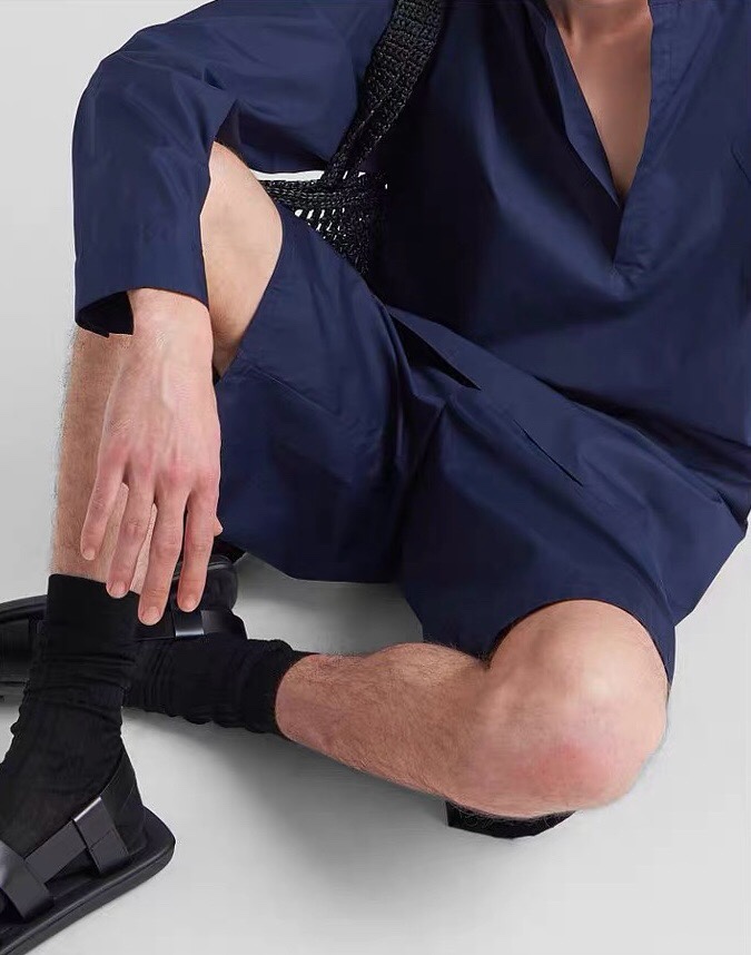 BGA136zydlb-男款极简风格三角标元素府绸棉松紧腰百慕大短裤，有同系列衬衫可搭配成套关于款式及设计：P家的海报款，以套装的形式，也可以各自分搭，属于风格化极强的一组单品，整体极简，骨子里有着很法式的老钱风。松紧腰的百慕大短裤，实穿度极高，整体偏极简，仅在后兜处保留了标志性的三角标徽章，配同系列衬衫整体感极强，用于搭配其他上衣，调性也十足，色调很时髦，偏黑的午夜蓝，把这一季的流行度拿捏到位。关于面料及工艺：A00%棉，高支棉质府绸，布面清爽，挺括有型，有一定