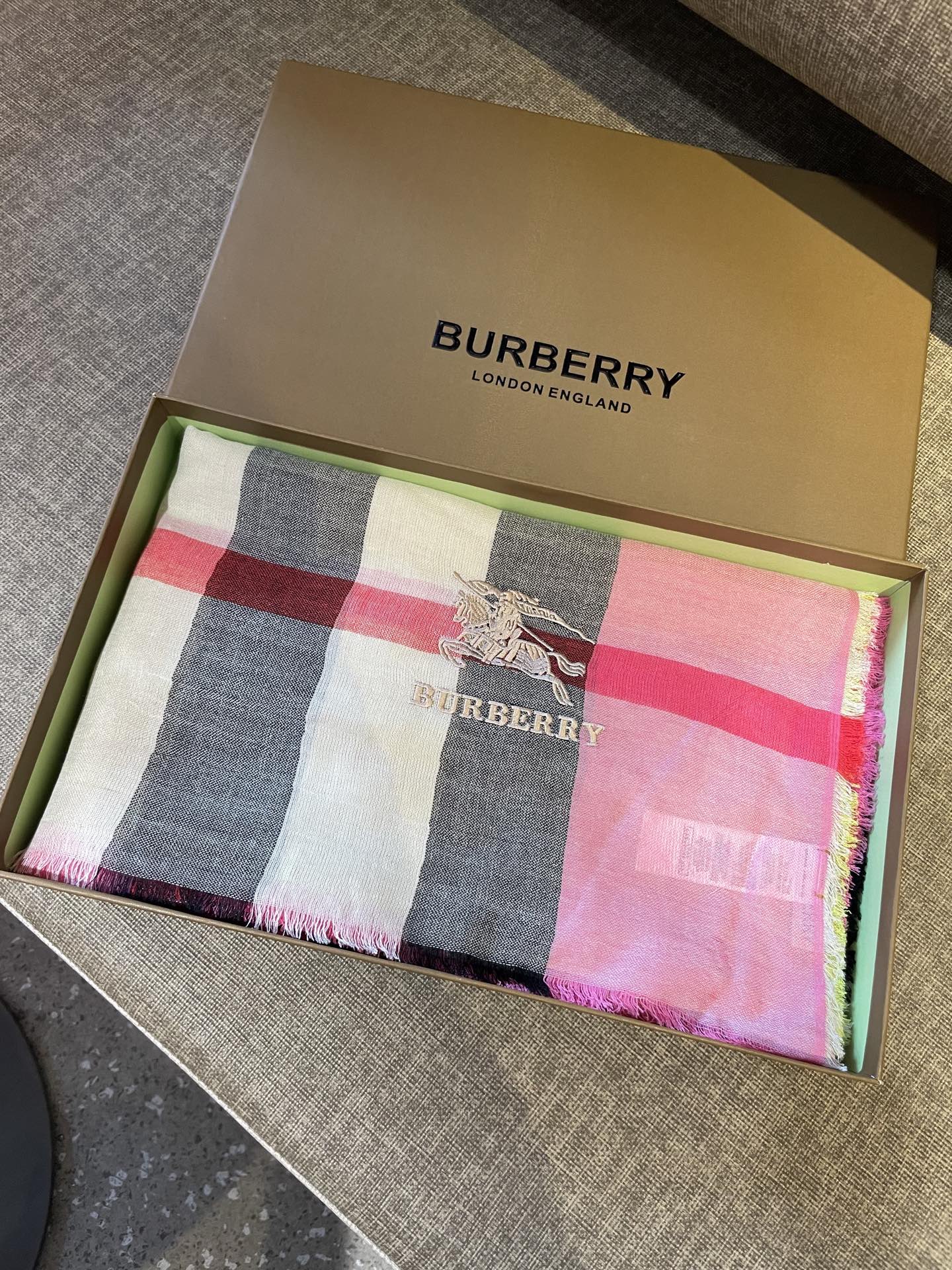 巴宝莉轻盈格纹围巾，精美马标刺绣logo，精湛制作工艺。首先臻选上乘的超细羊毛纤维，进行纯手工精梳处理，