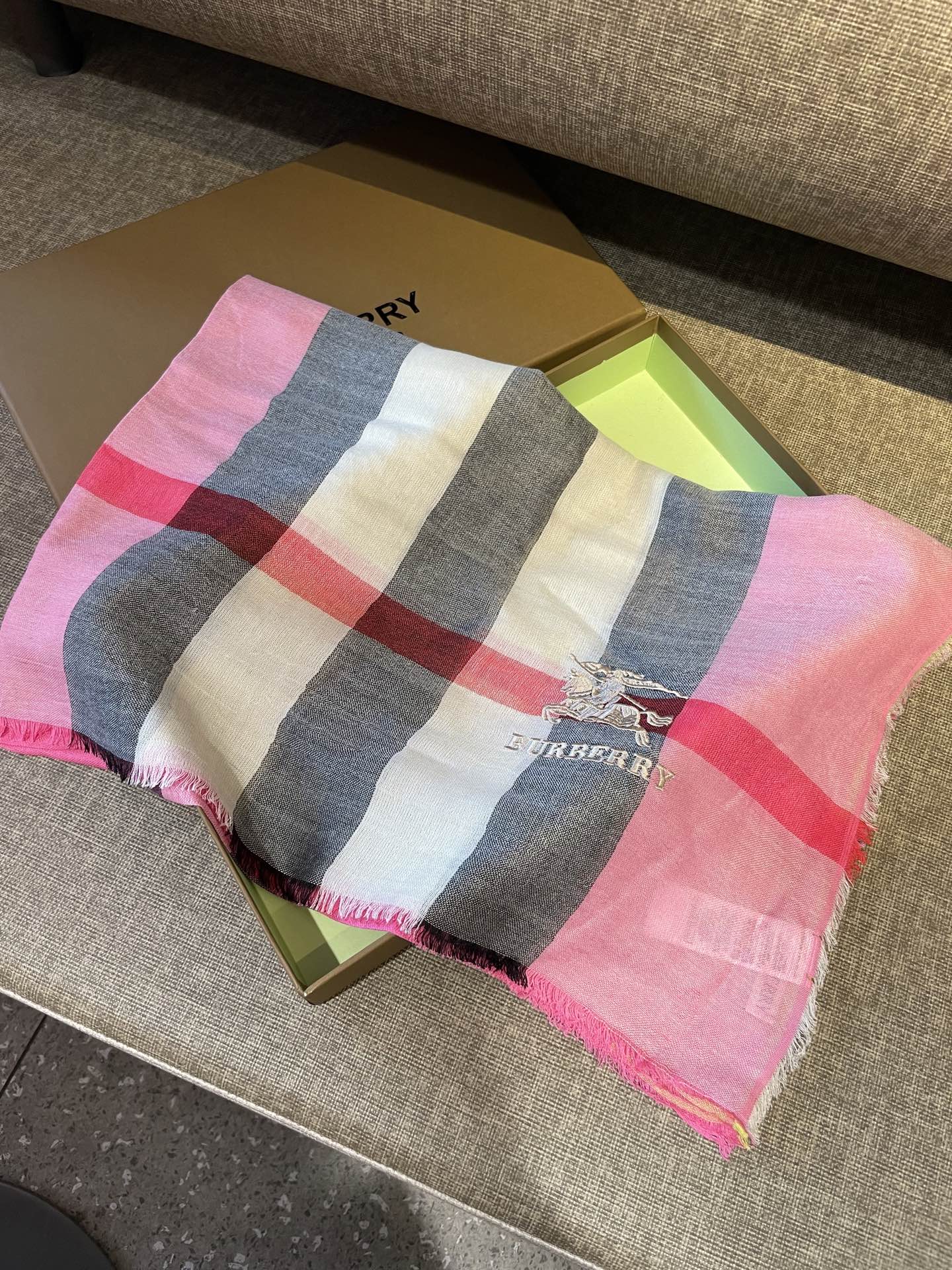 巴宝莉轻盈格纹围巾，精美马标刺绣logo，精湛制作工艺。首先臻选上乘的超细羊毛纤维，进行纯手工精梳处理，