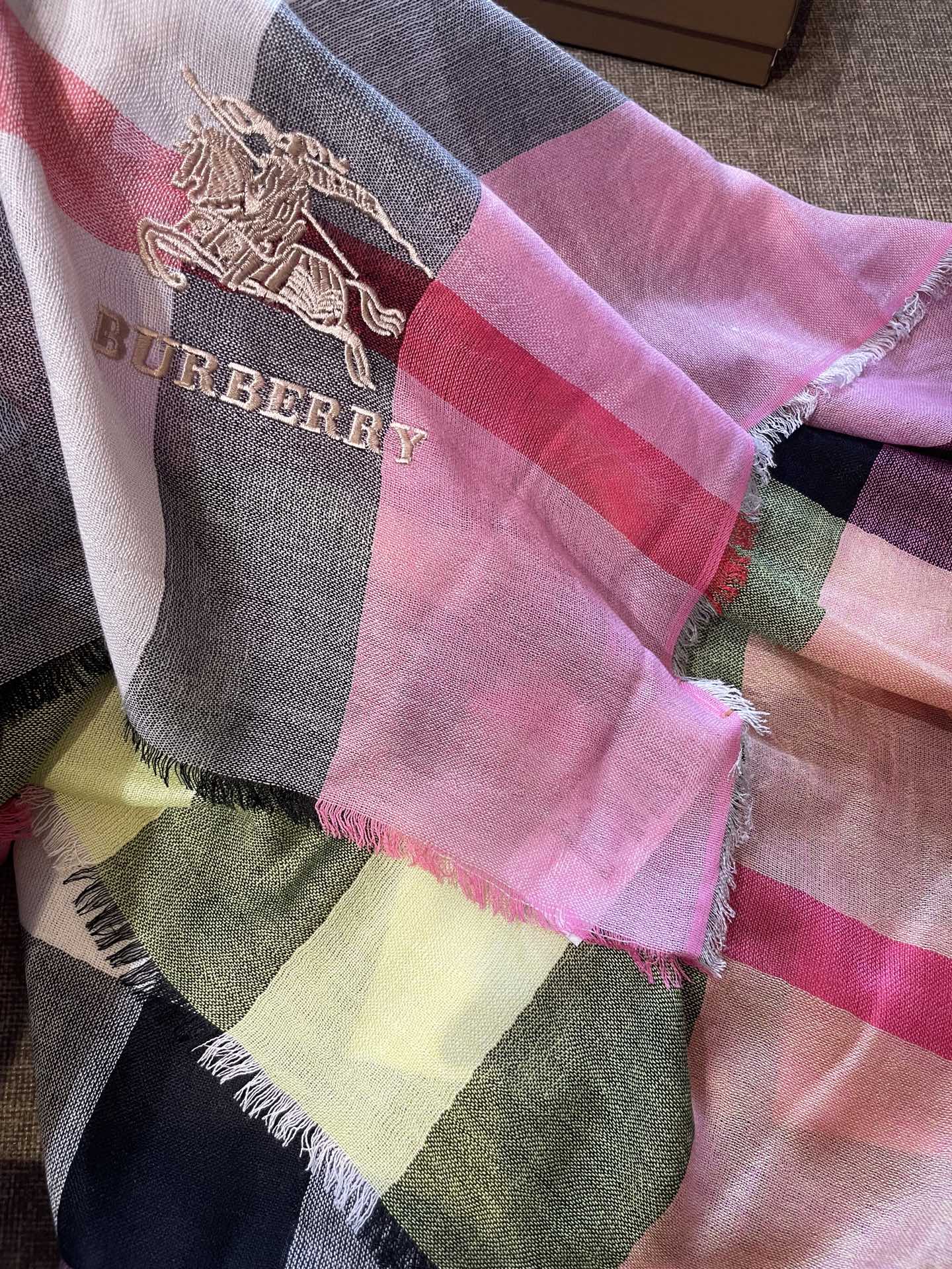 巴宝莉轻盈格纹围巾，精美马标刺绣logo，精湛制作工艺。首先臻选上乘的超细羊毛纤维，进行纯手工精梳处理，